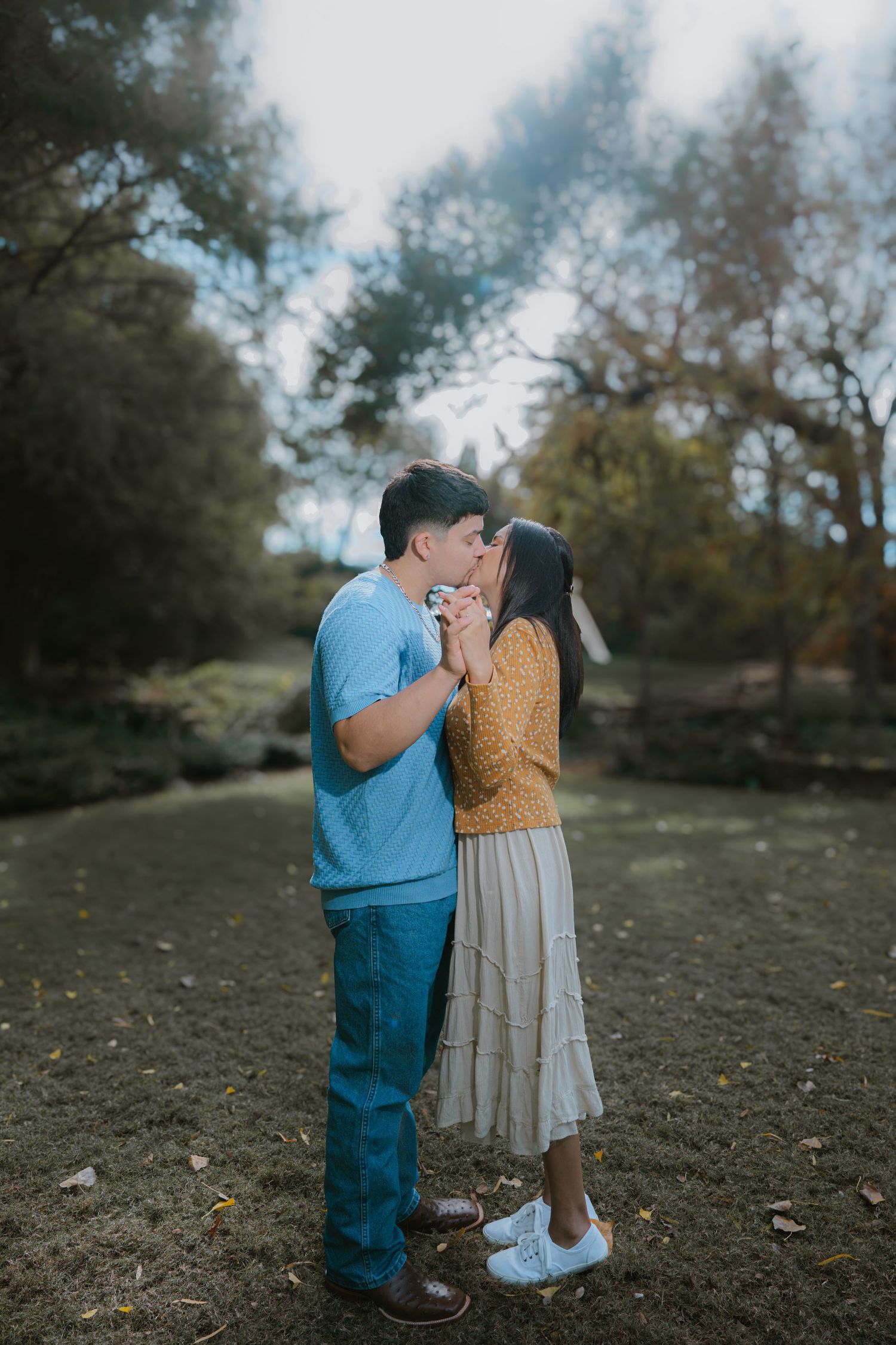 A tender moment captured between two people during a proposal in a garden setting.