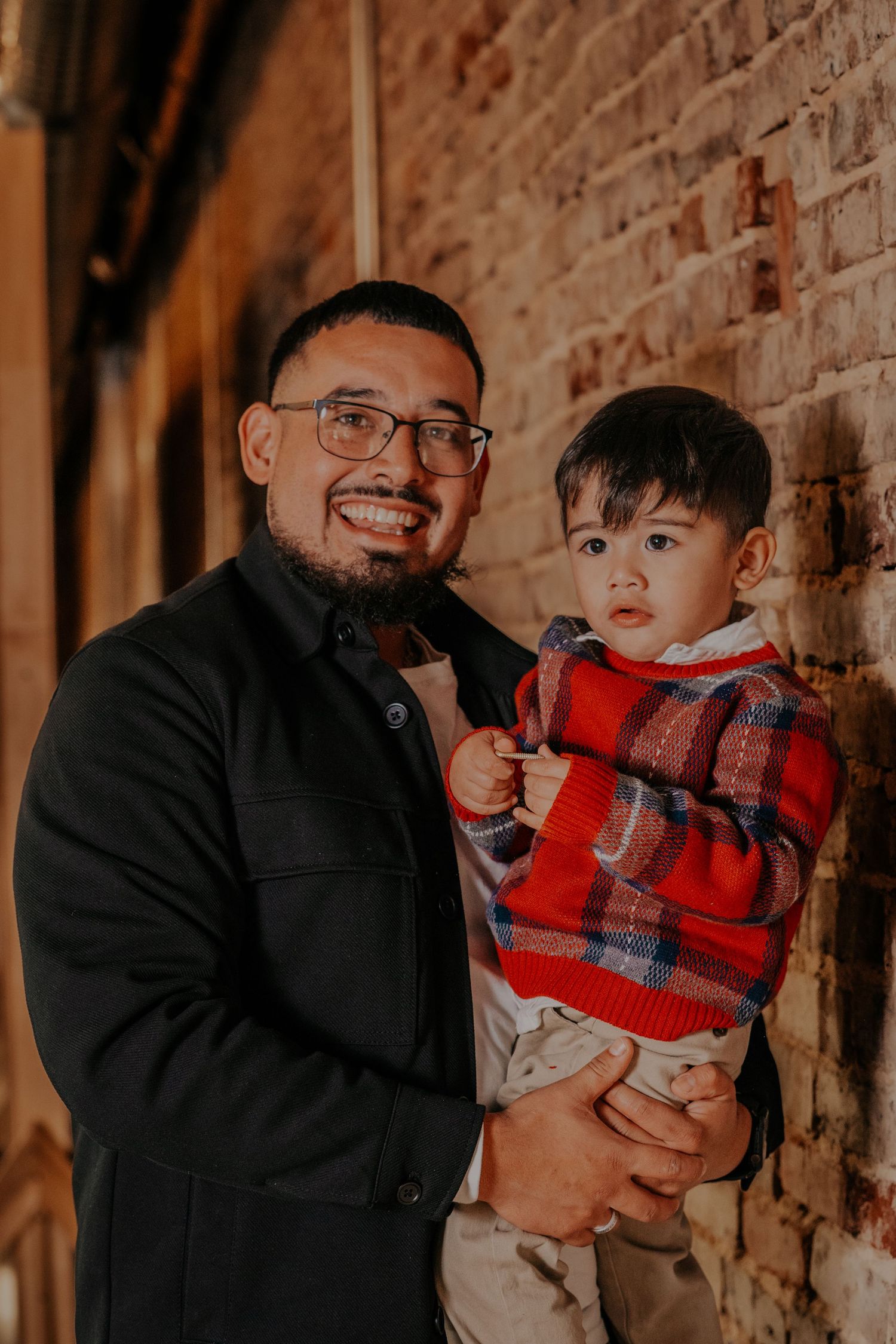 A series of candid family moments captured against a rustic brick wall background in warm lighting.