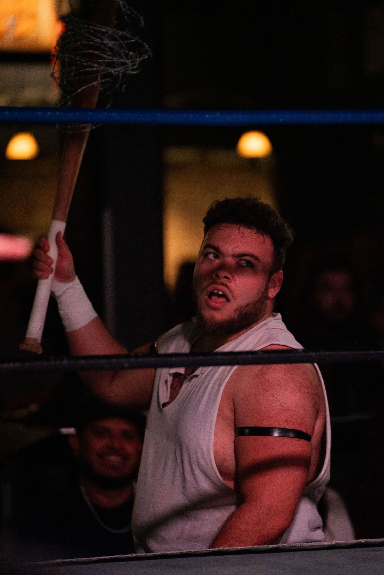 Professional wrestler lying on the mat during an intense match.