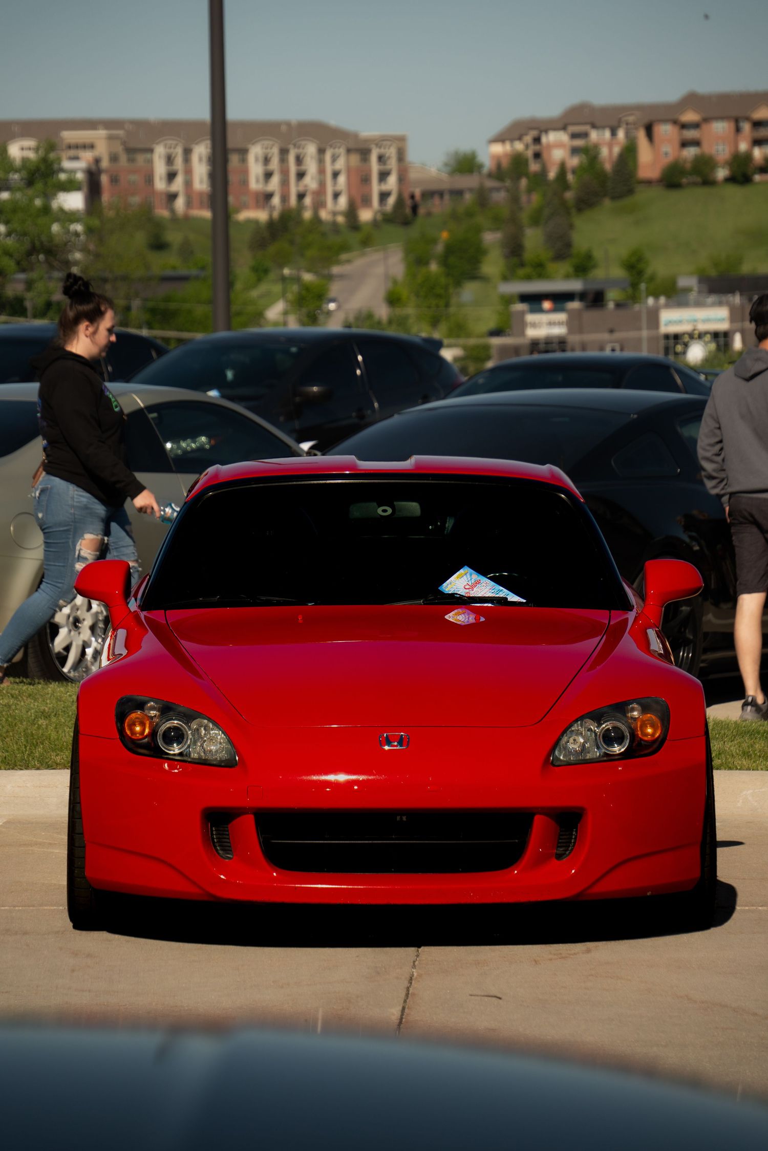 Line of red sports cars displayed at an outdoor car show.