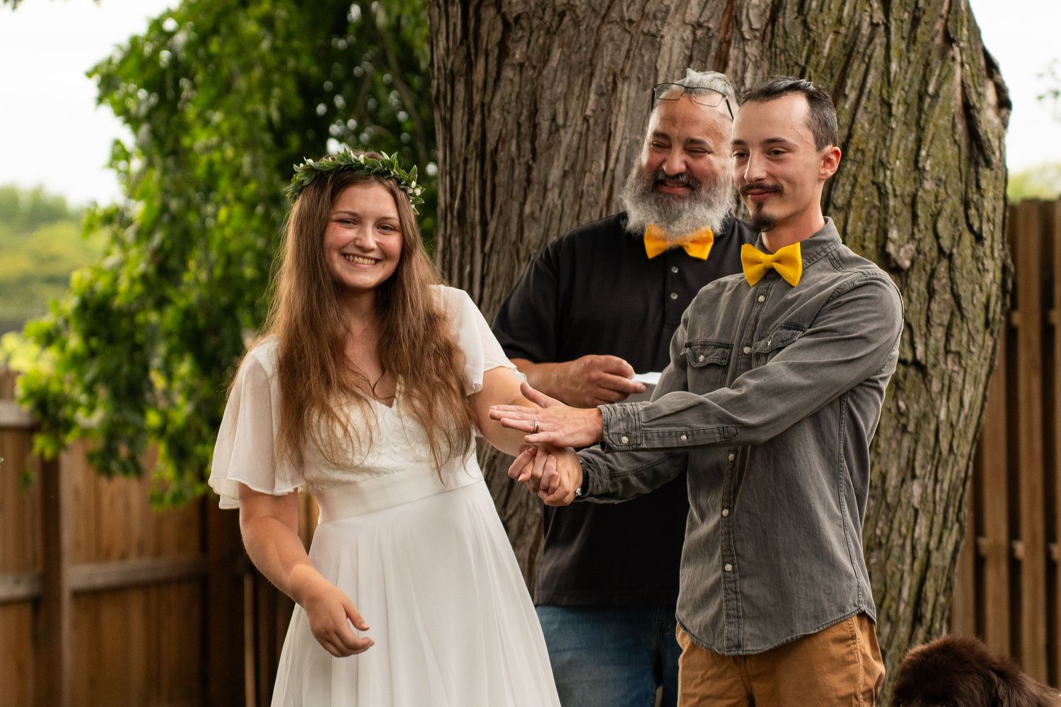 Outdoor family portrait session under a large tree in natural lighting.
