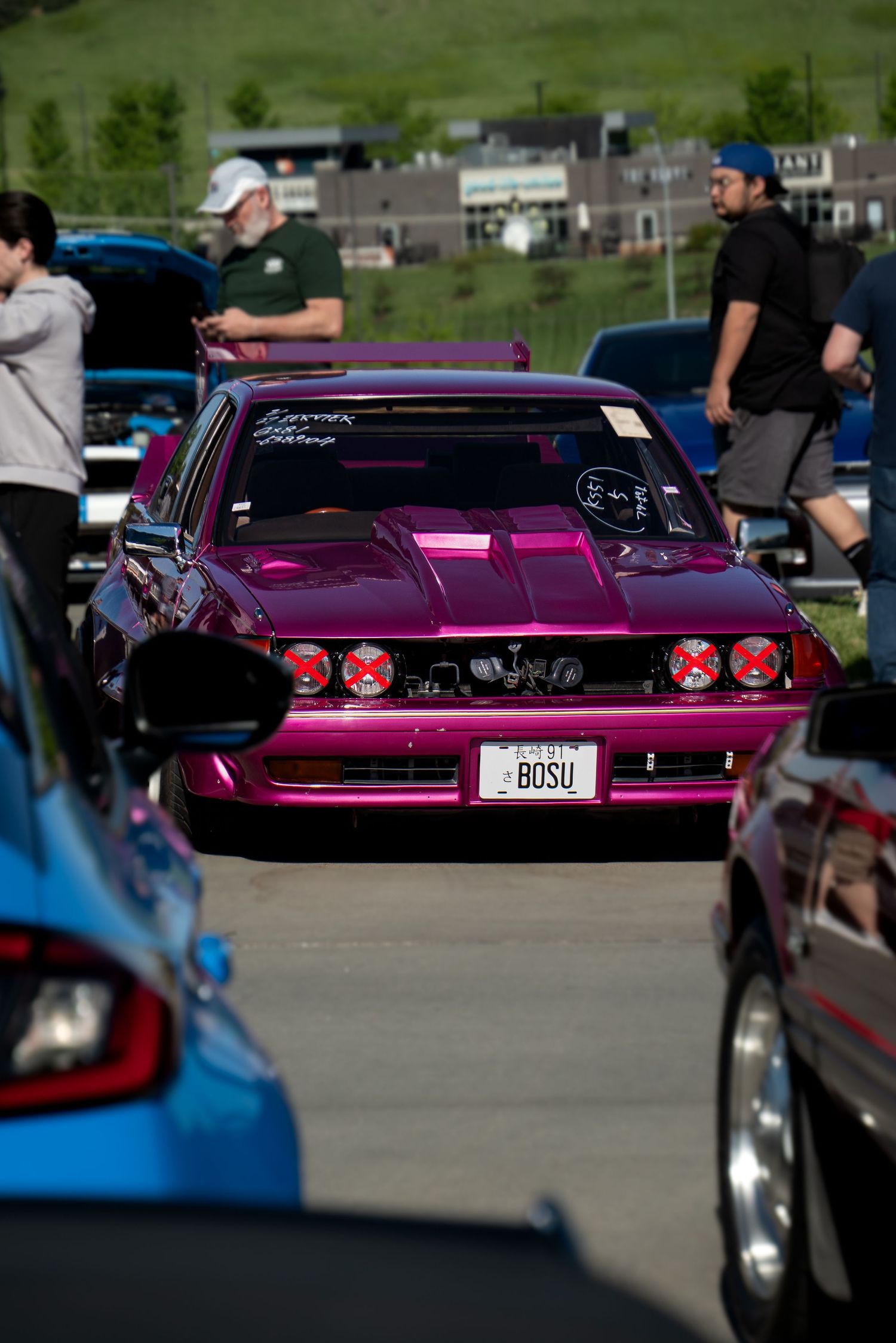 Purple custom car with distinctive rear styling photographed at a car meet.