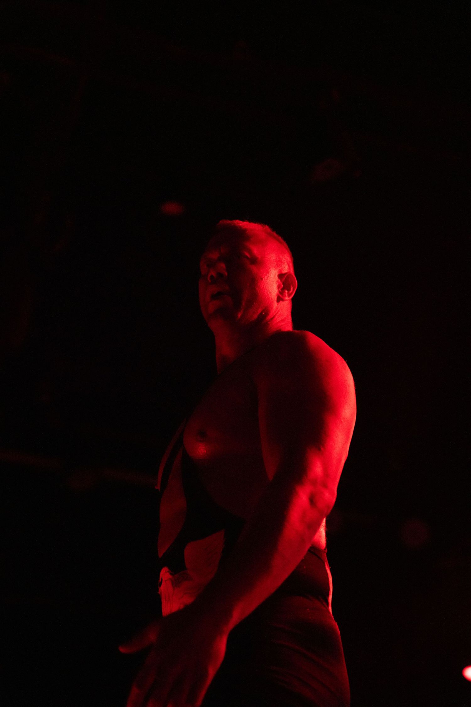 Dramatic red-lit silhouette of a wrestler during a performance.