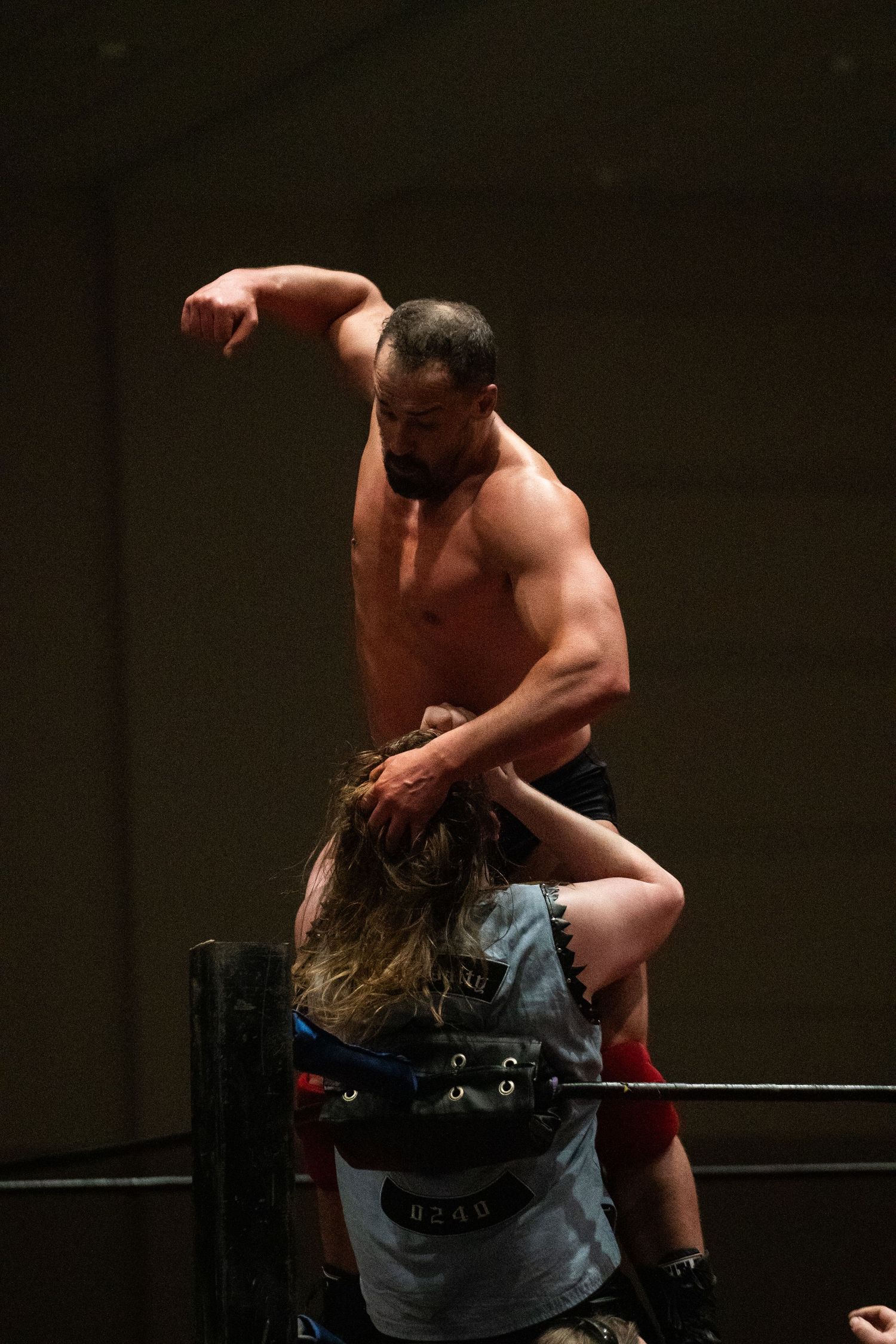Wrestling match action captured in dramatic low-light conditions.