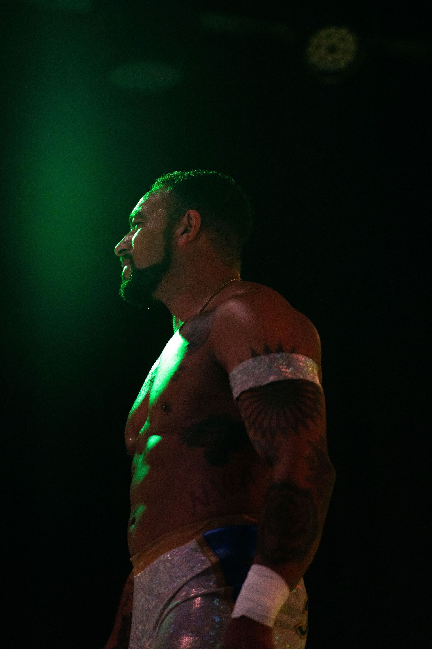 Stage performer bathed in dramatic green lighting during a show.