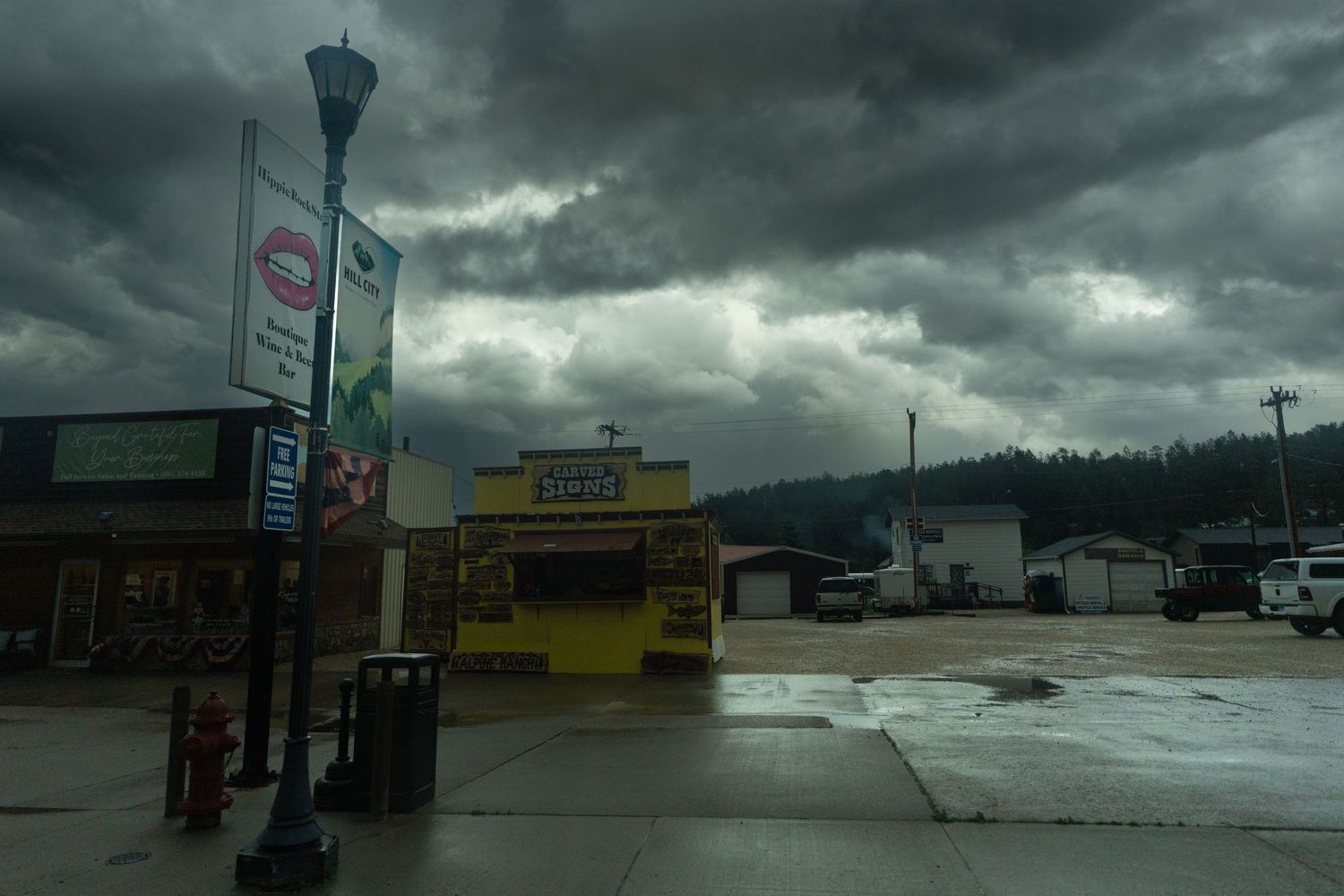 Dramatic stormy sky over a strip mall parking lot with dark clouds and ominous atmosphere.