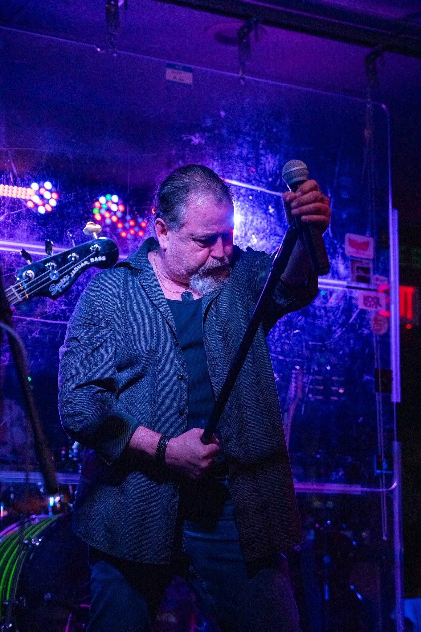 Musicians perform on stage under dramatic blue lighting at a nightclub venue.