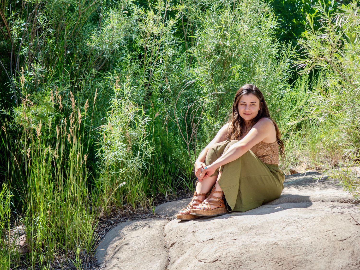 A series of outdoor portraits showing a person relaxing on a rocky surface surrounded by lush green plants and foliage.