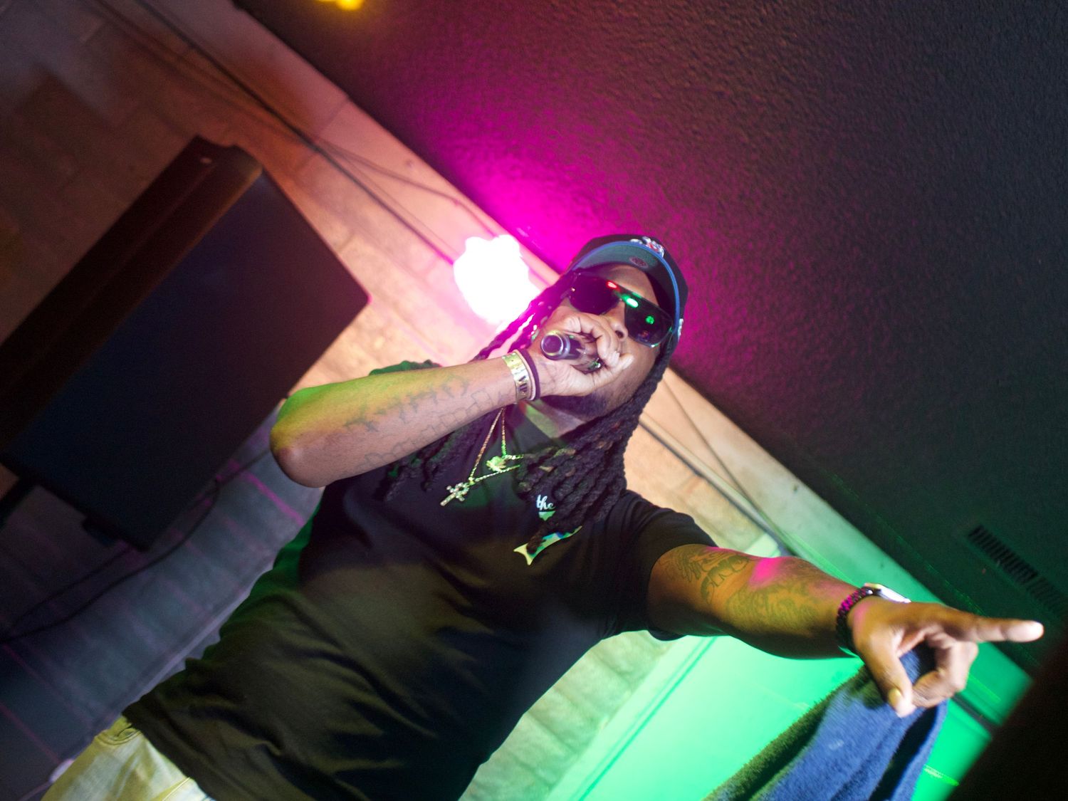 DJ performs behind mixing decks with colorful neon lighting effects in a nightclub atmosphere.