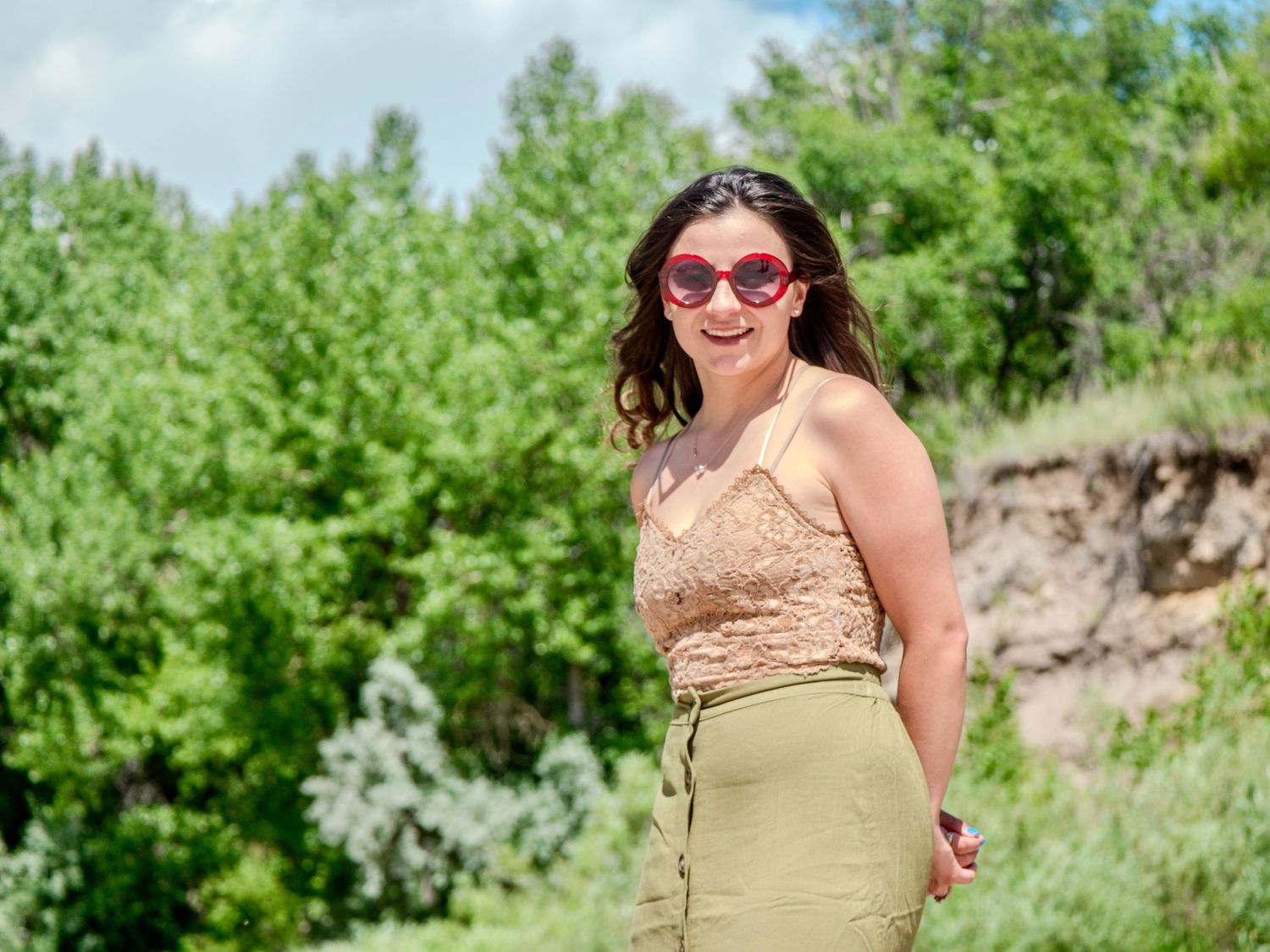A series of outdoor portraits showing someone with sunglasses in a yellow dress posing against a natural landscape backdrop.