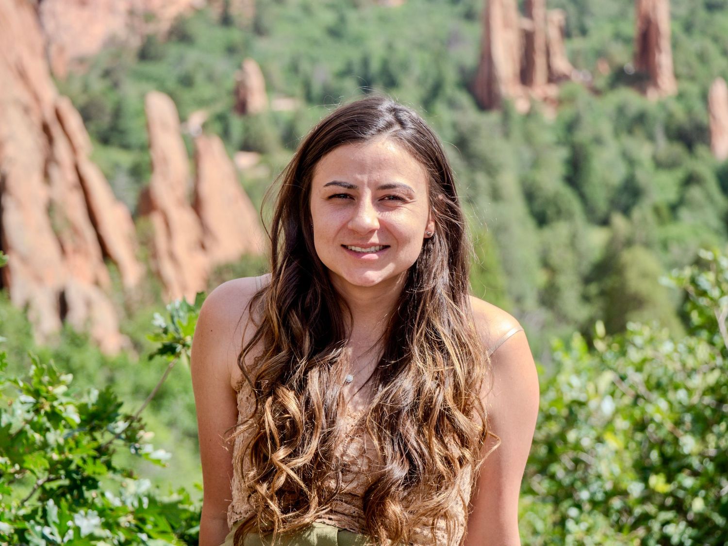 Four similar photos showing someone posing in front of scenic red rock formations and green trees in nature.