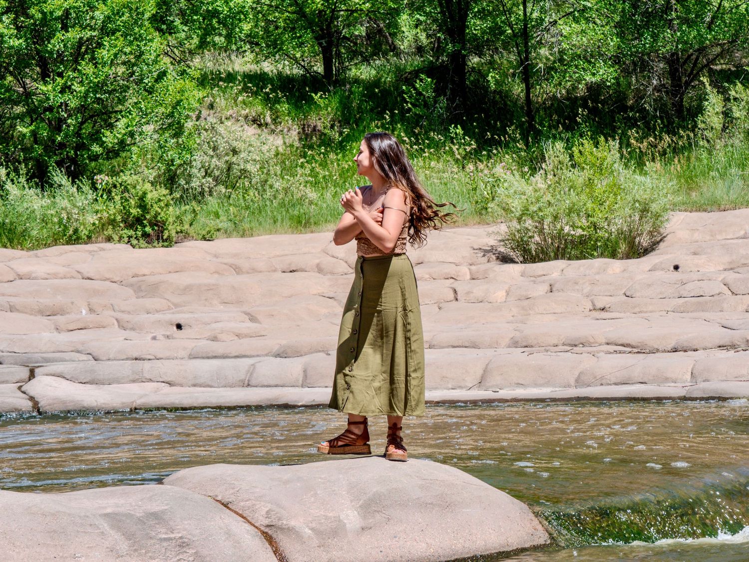 A hiker exploring the rocky terrain near a flowing creek in a natural outdoor setting.