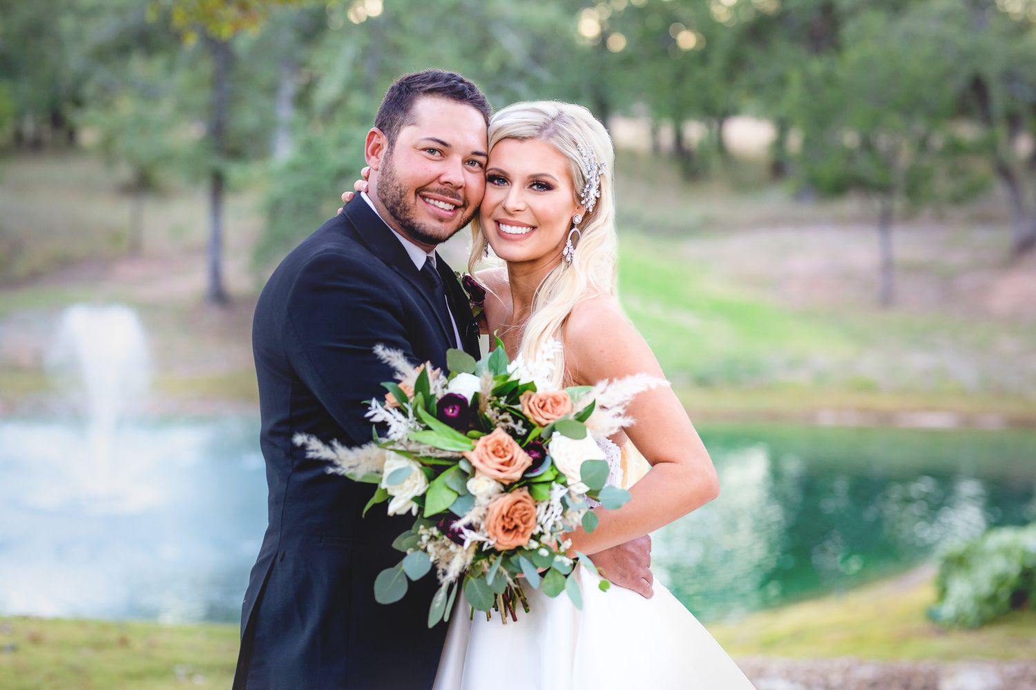 Wedding couple shares romantic moments in front of a scenic lake backdrop.