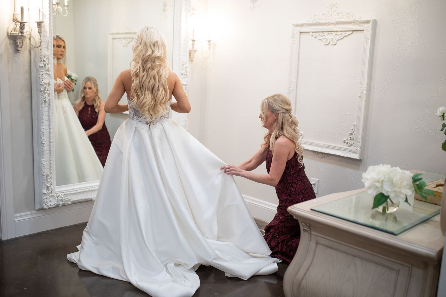 Bridal preparation room with ornate mirrors and elegant white decor.