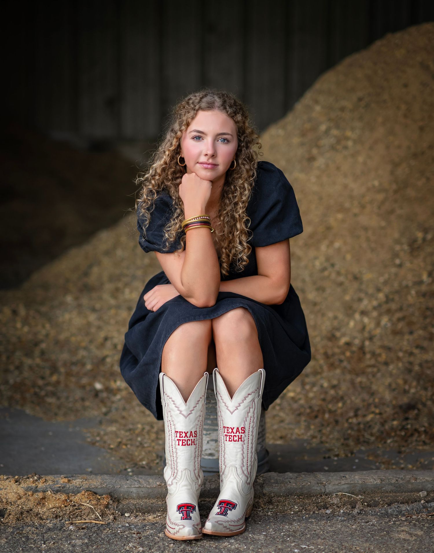 White cowboy boots with Texas Tech logo featured in creative outdoor portrait series.