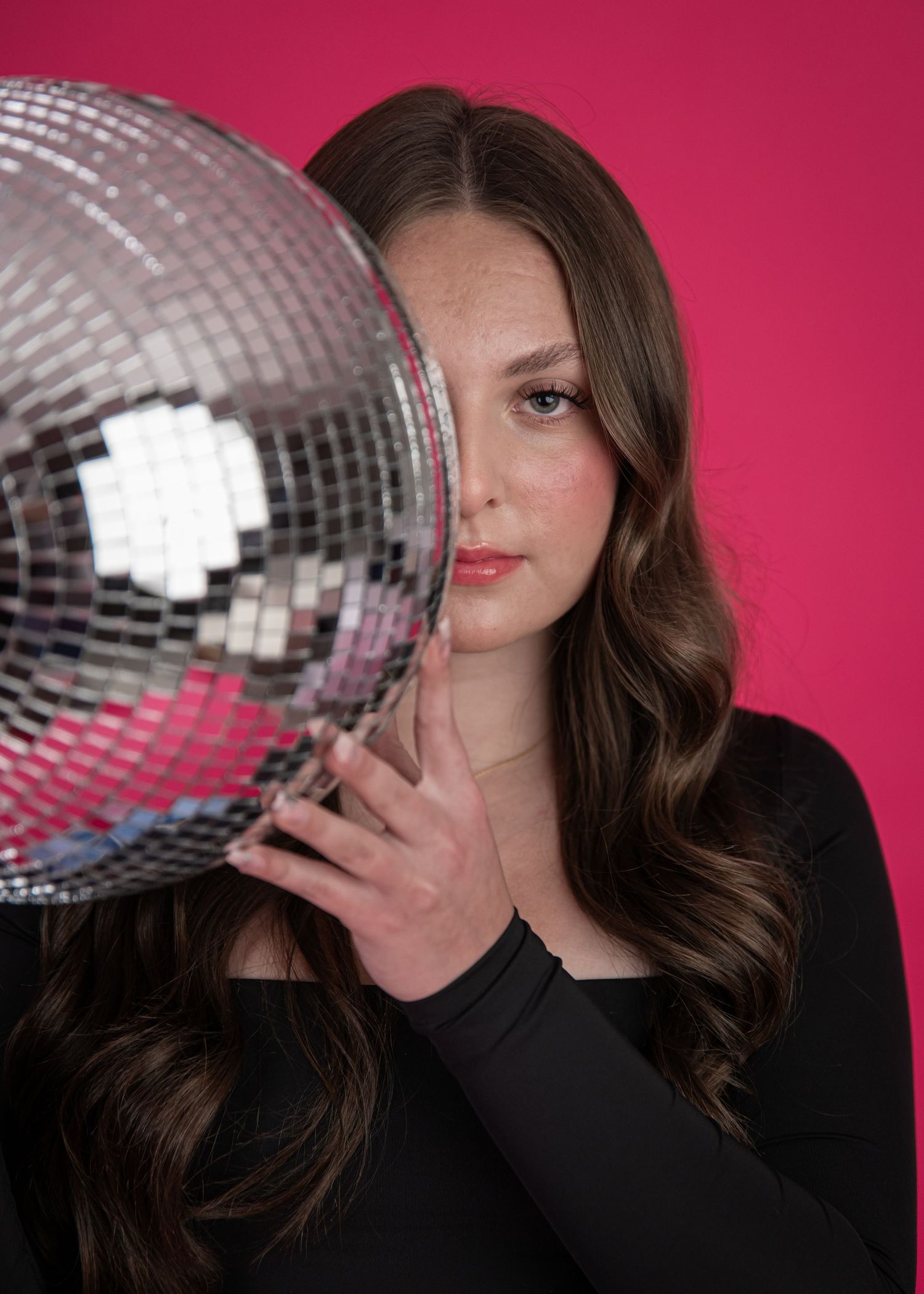 A creative photo sequence with a disco ball and someone wearing black against a pink backdrop.