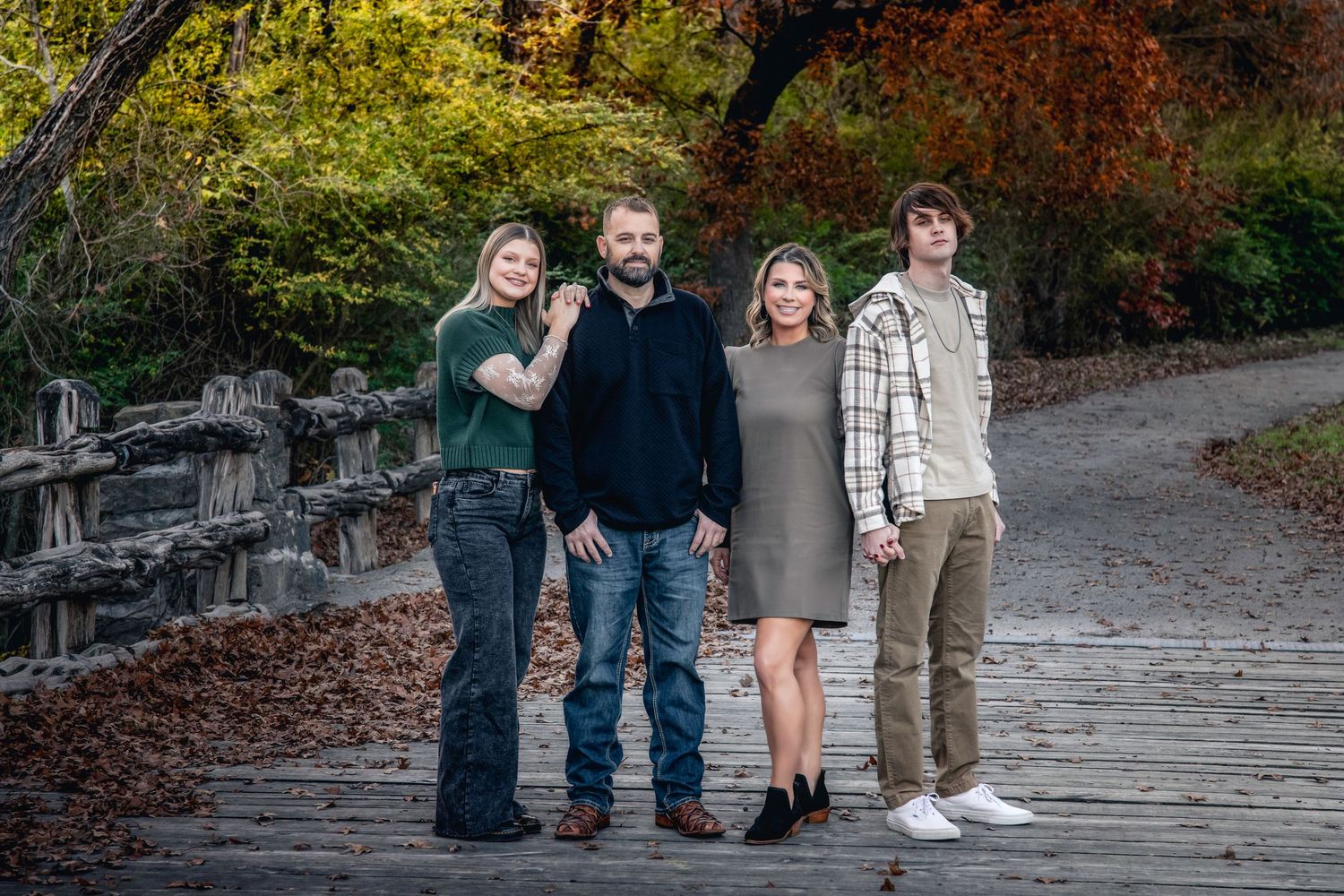 Playful group poses together on stone steps surrounded by autumn foliage.