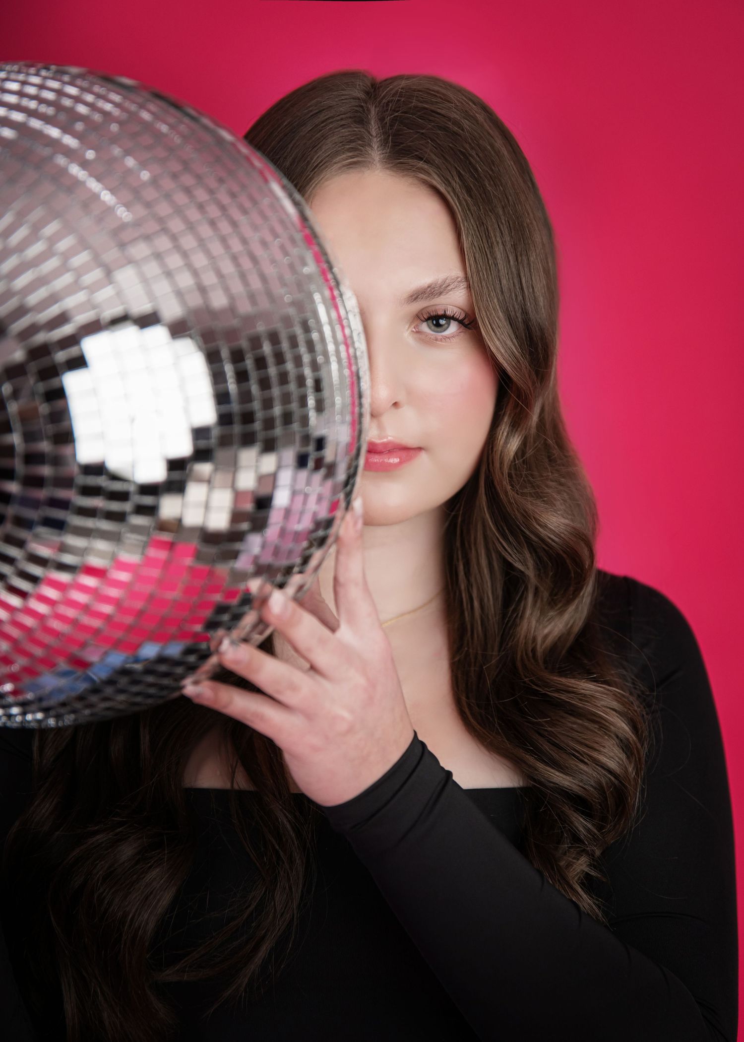 Artistic portrait series with a silver disco ball against a vibrant pink background showcasing elegant poses.