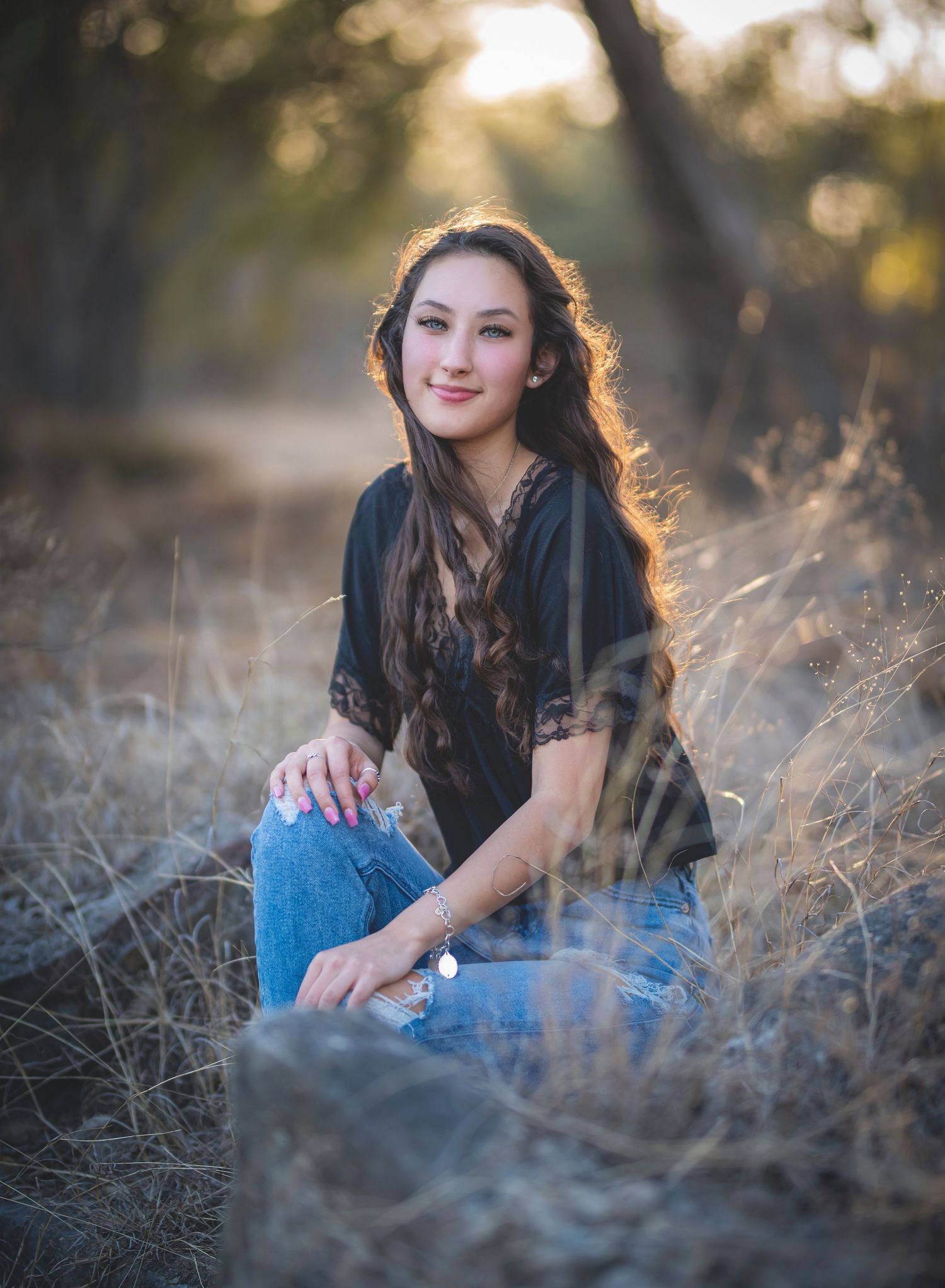 Candid outdoor portrait in tall grass during golden sunset light.