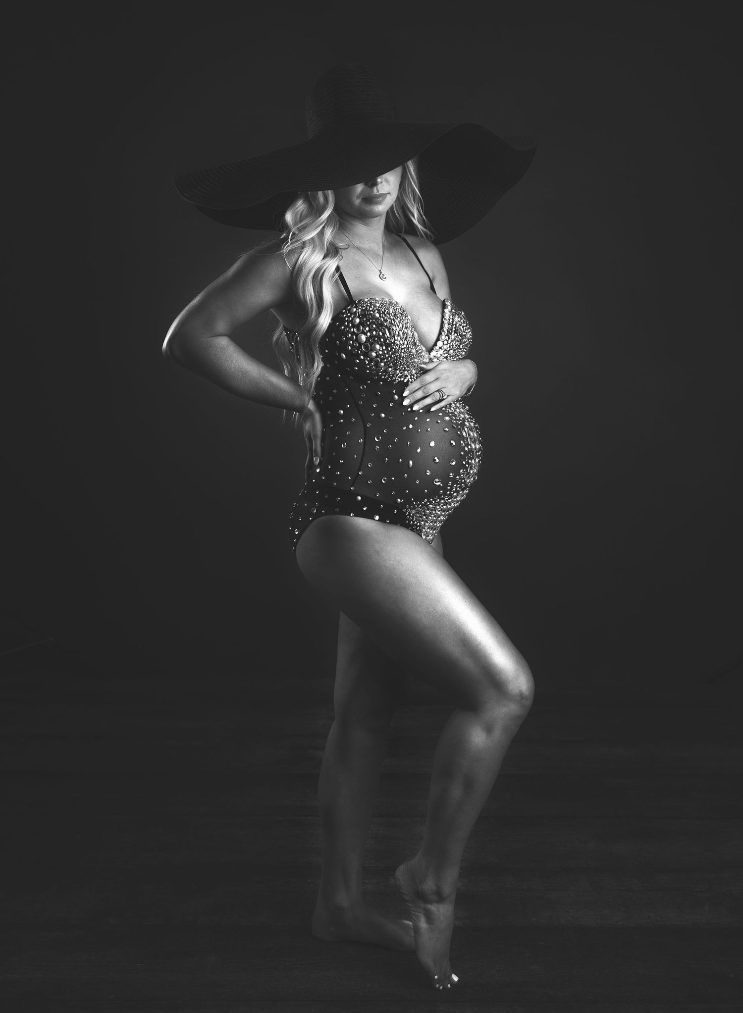 Artistic low-key boudoir photography with dramatic lighting and movement.