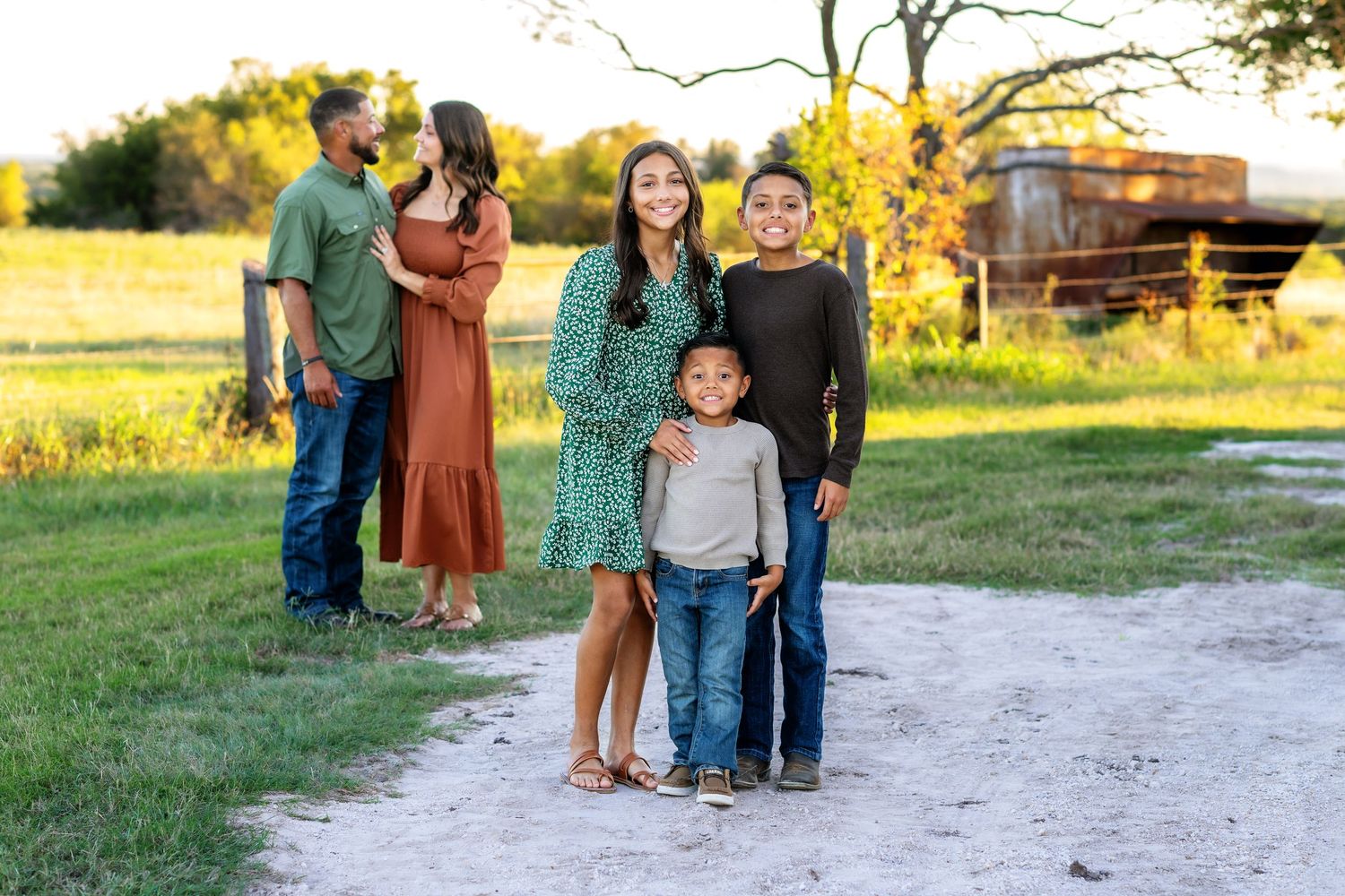 Family captures candid moment on dirt path during outdoor photo session.