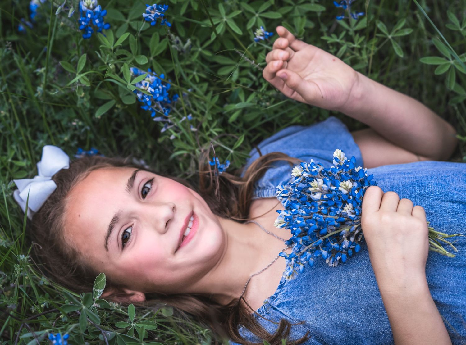 Portrait in a field of blue wildflowers with a flowing blue dress.
