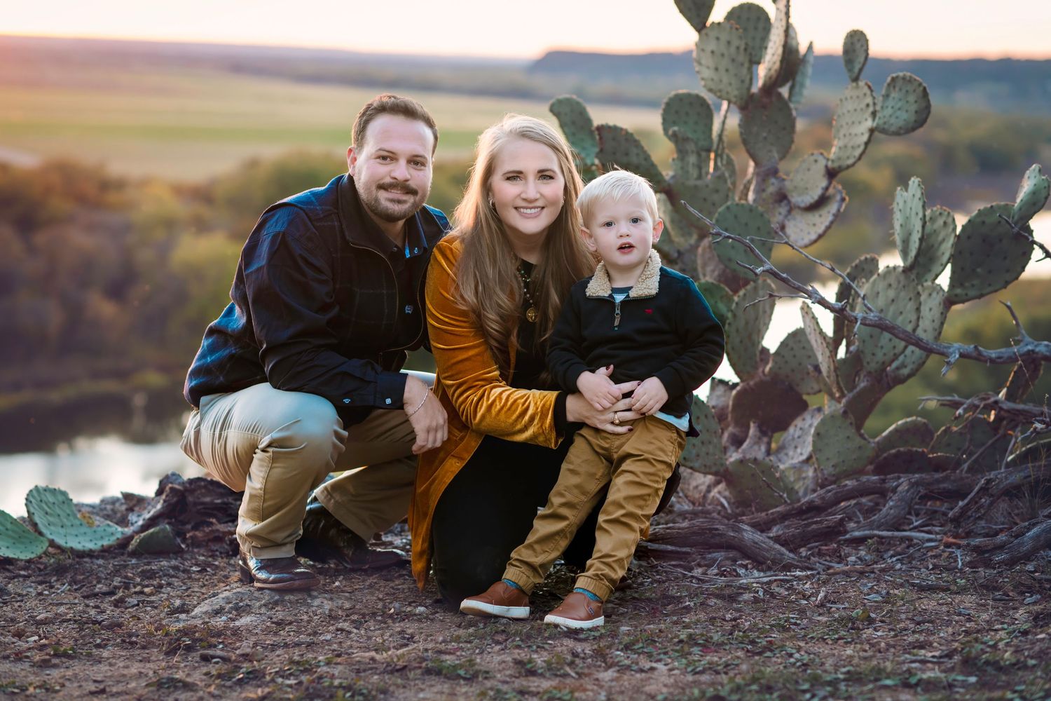 Family portrait session among desert cacti during golden hour sunset.