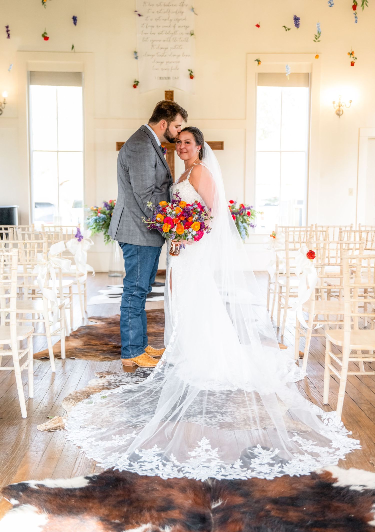 Wedding ceremony venue with white chairs and dramatic train of bridal gown.