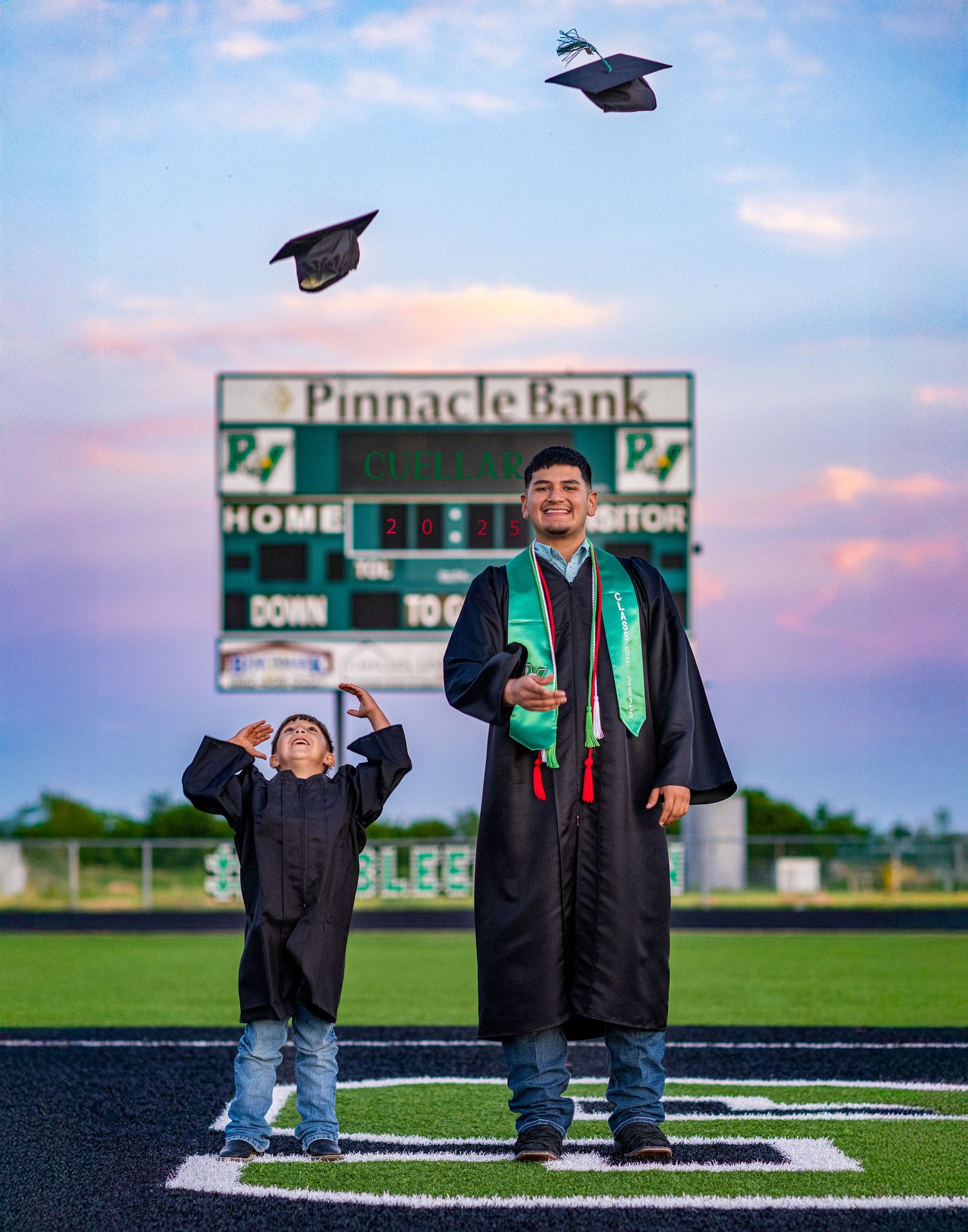 Graduation photos taken on a football field at sunset with a Pinnacle Bank sign visible in the background.