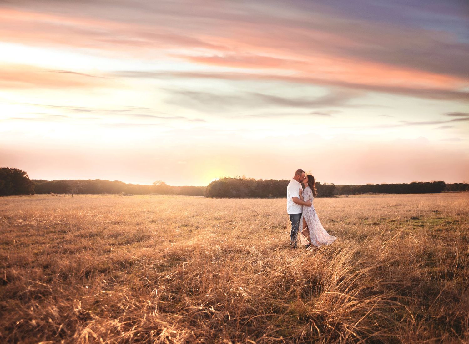 Panoramic sunset engagement photos in golden field with warm evening light.