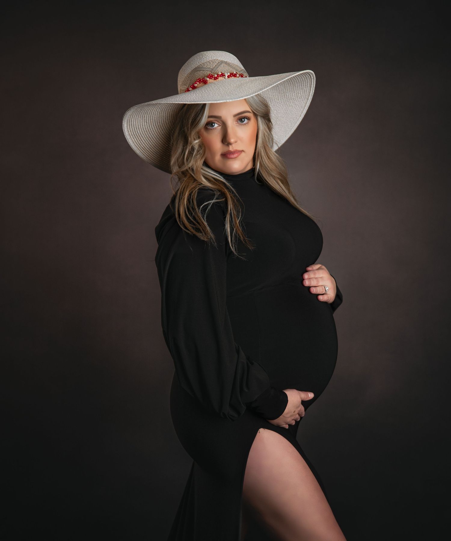 Studio portrait series with black sweater and white wide-brimmed hat.