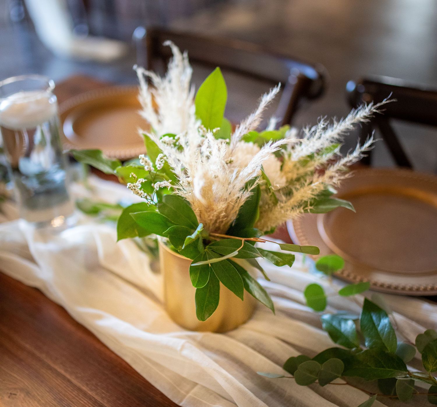 Fresh green floral arrangements and delicate ribbons laid out on wooden surface.
