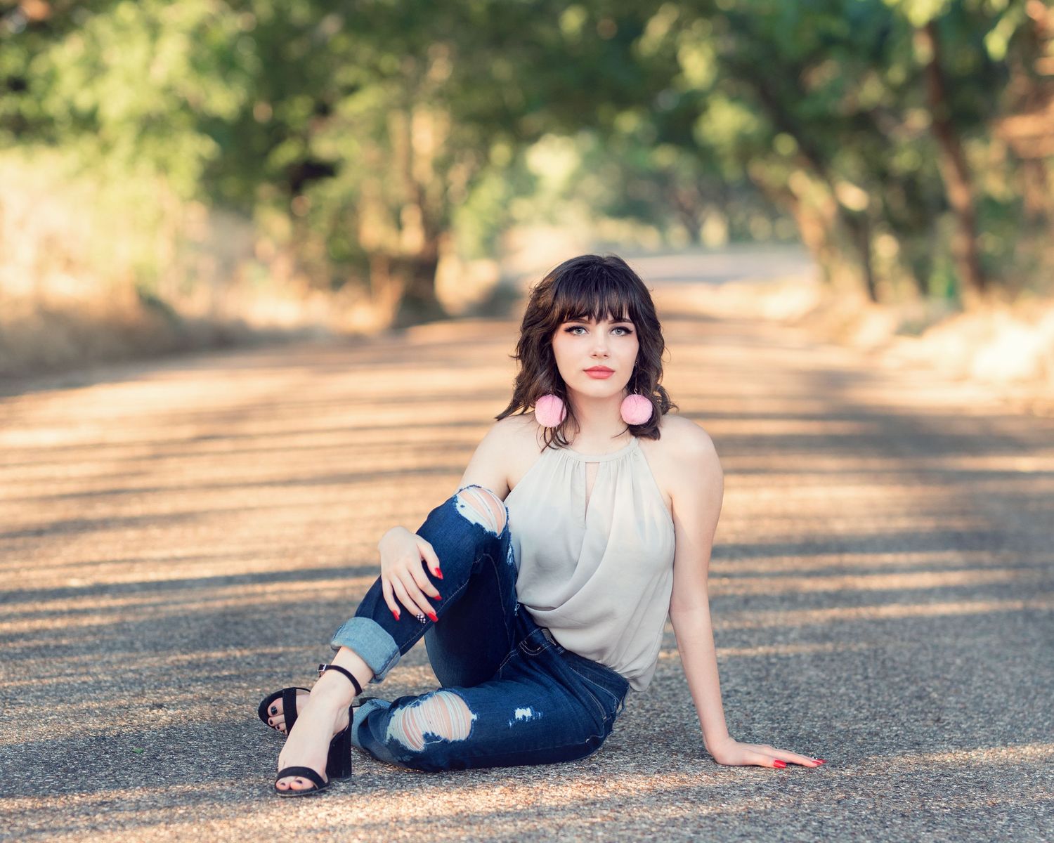 Casual outdoor portrait session on asphalt during golden hour lighting.