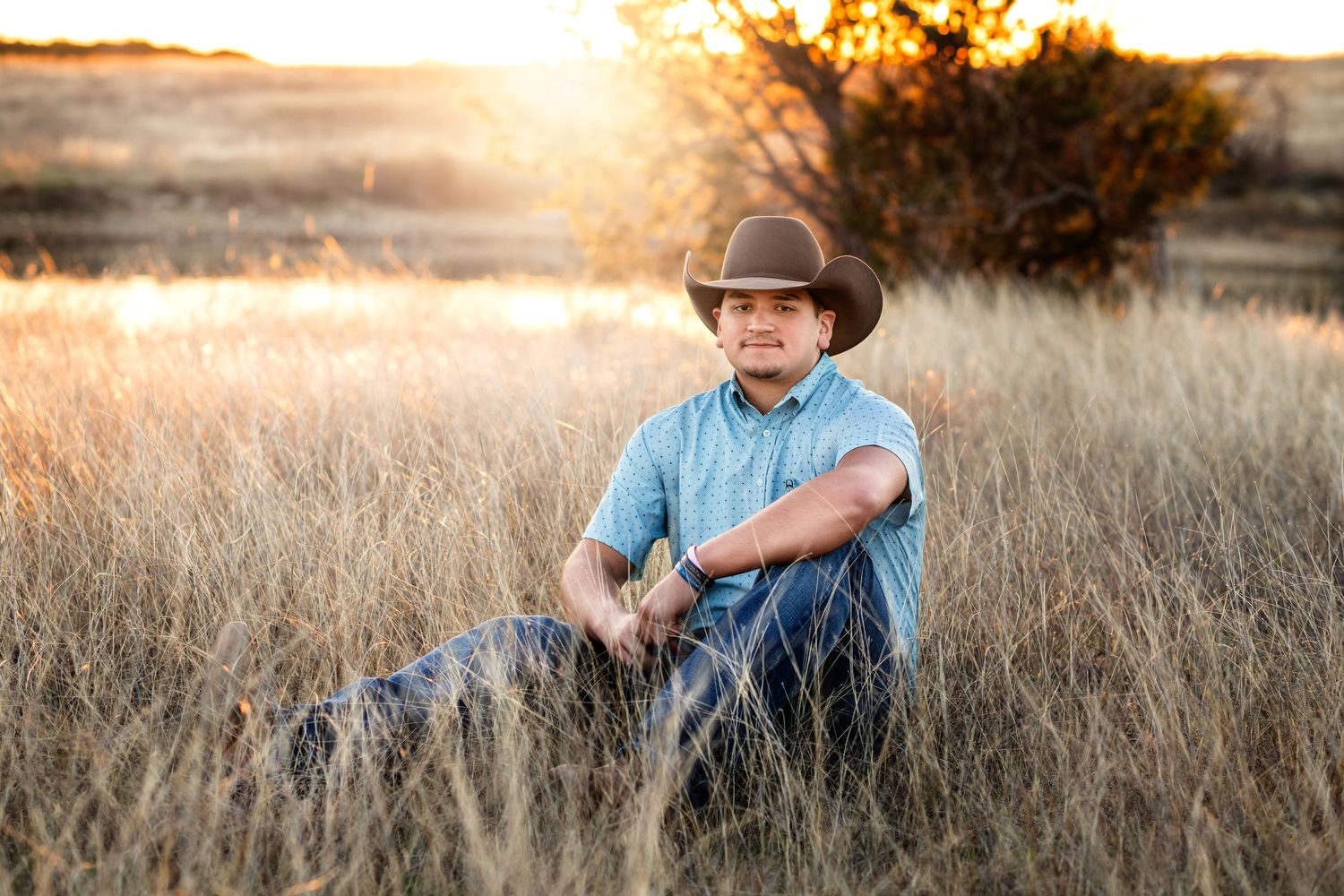 Rustic outdoor portrait in golden field during sunset light.