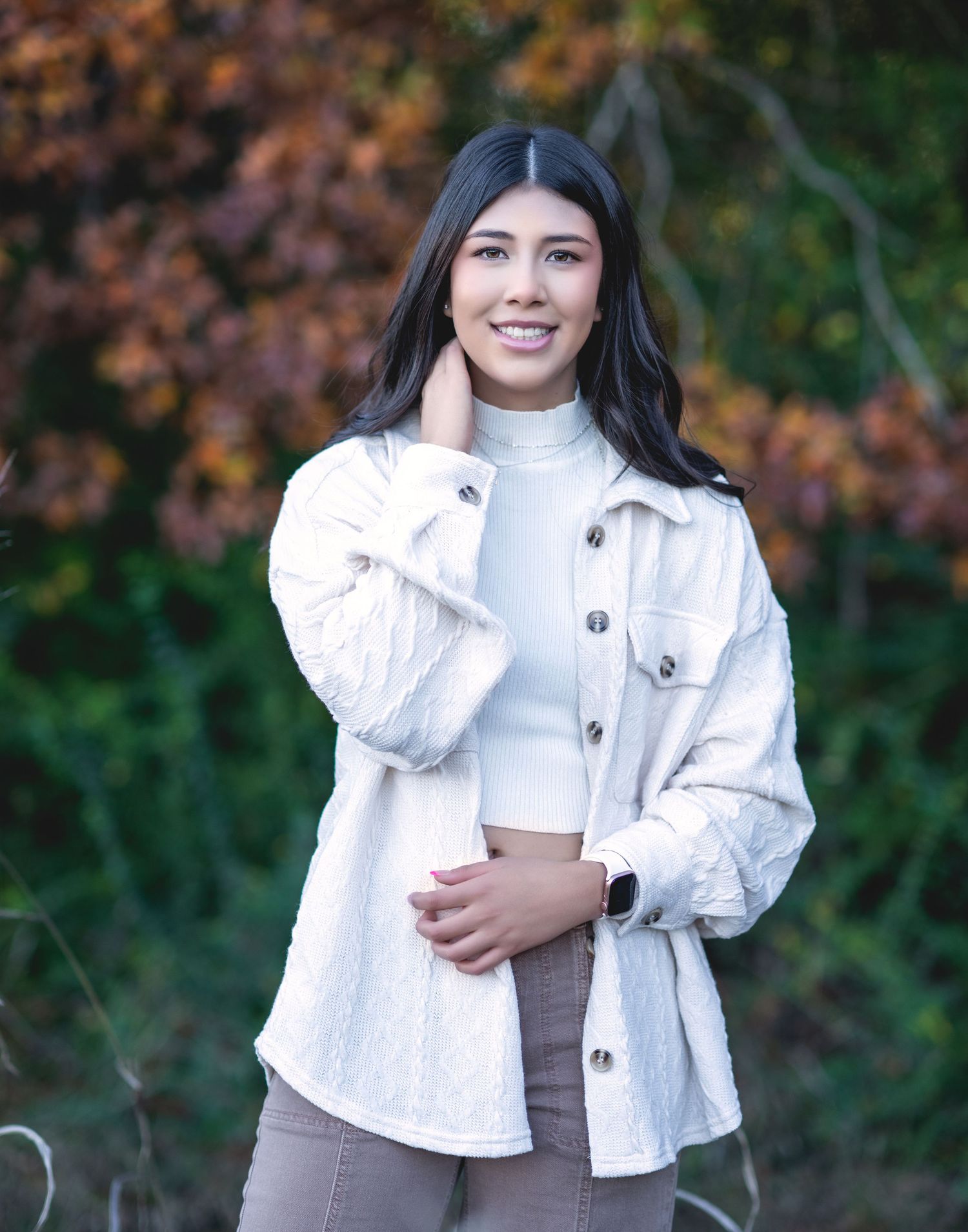 Casual autumn portrait in white jacket against fall foliage.