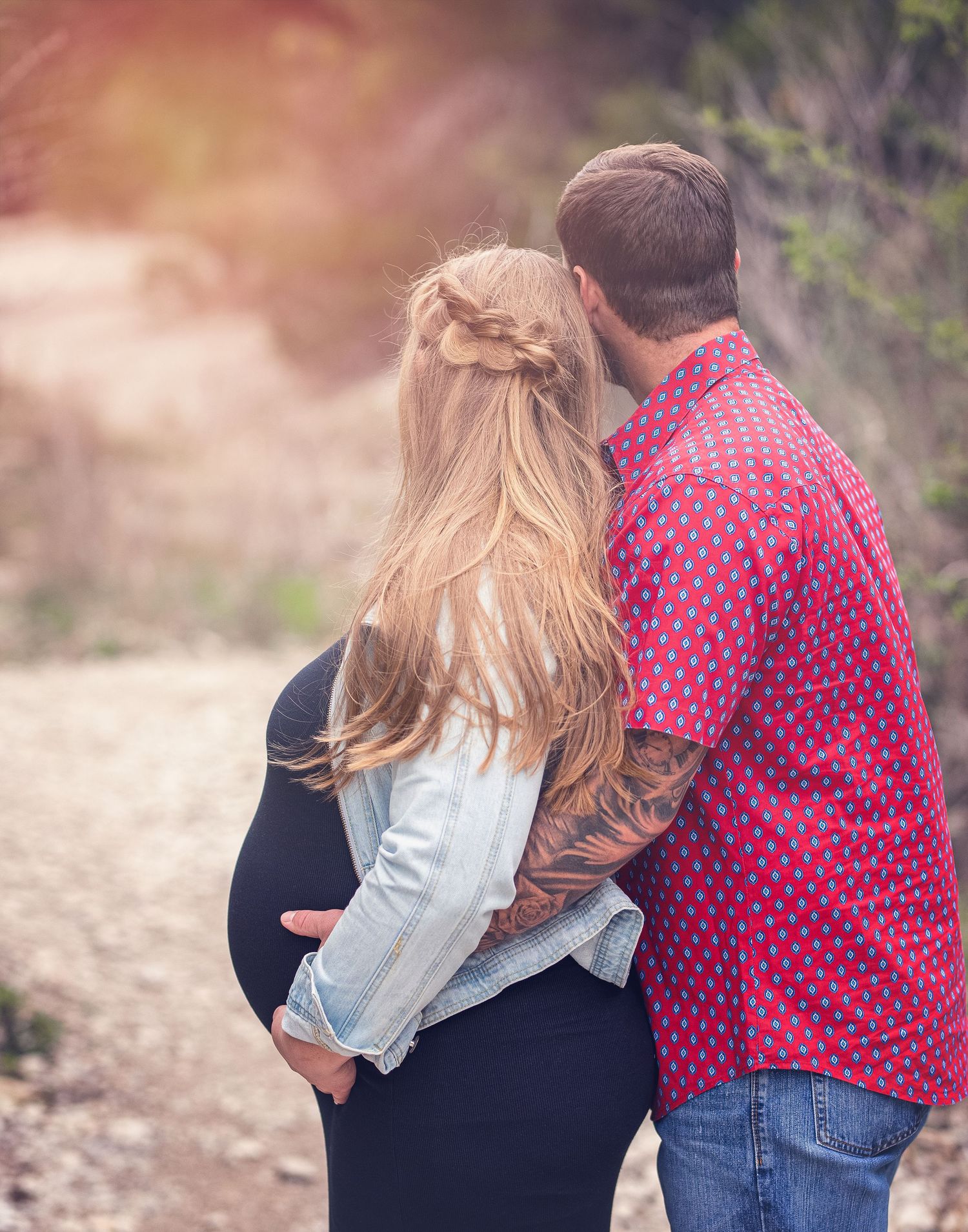 Sweet outdoor engagement session showing couple in denim and pink clothing.