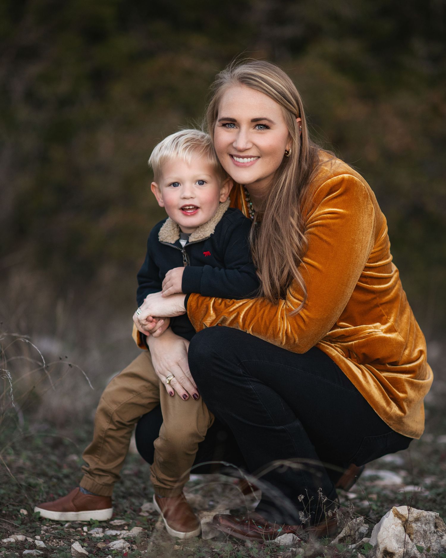 Intimate family portraits with rust velvet jacket against natural outdoor setting.
