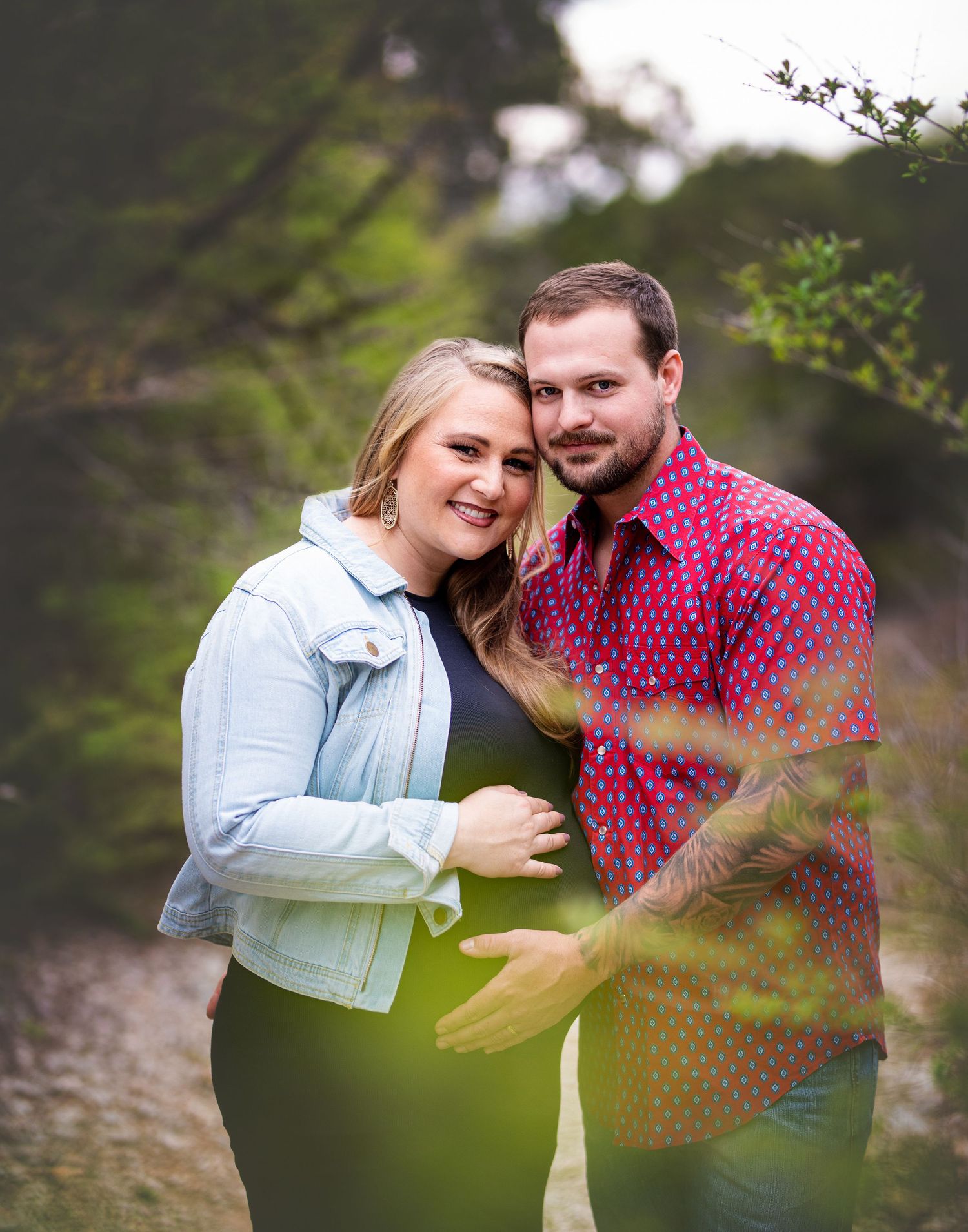 Romantic engagement photos of couple embracing in casual denim and pink outfits.