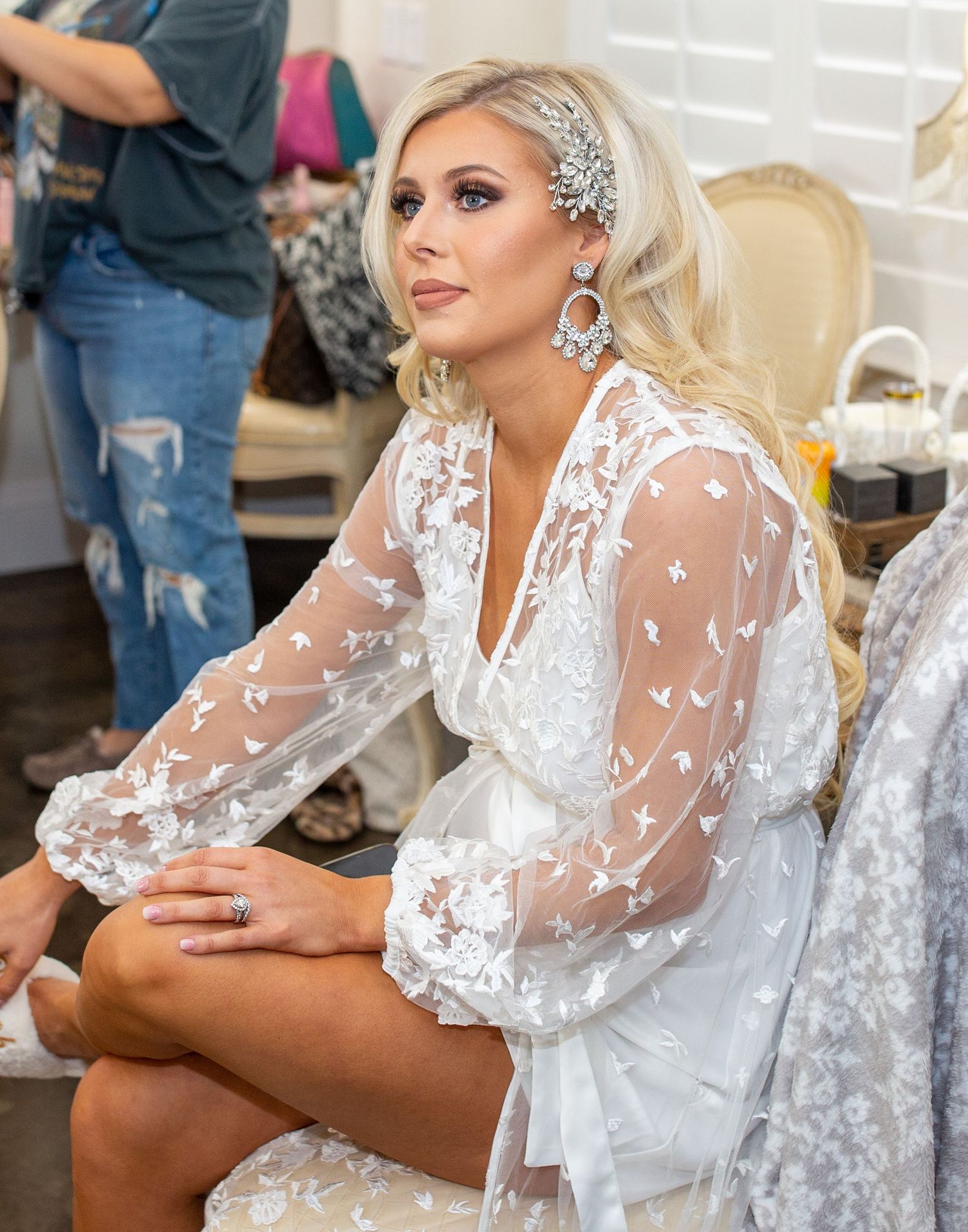 Romantic bridal portrait featuring delicate lace sleeves and crystal hair accessories.