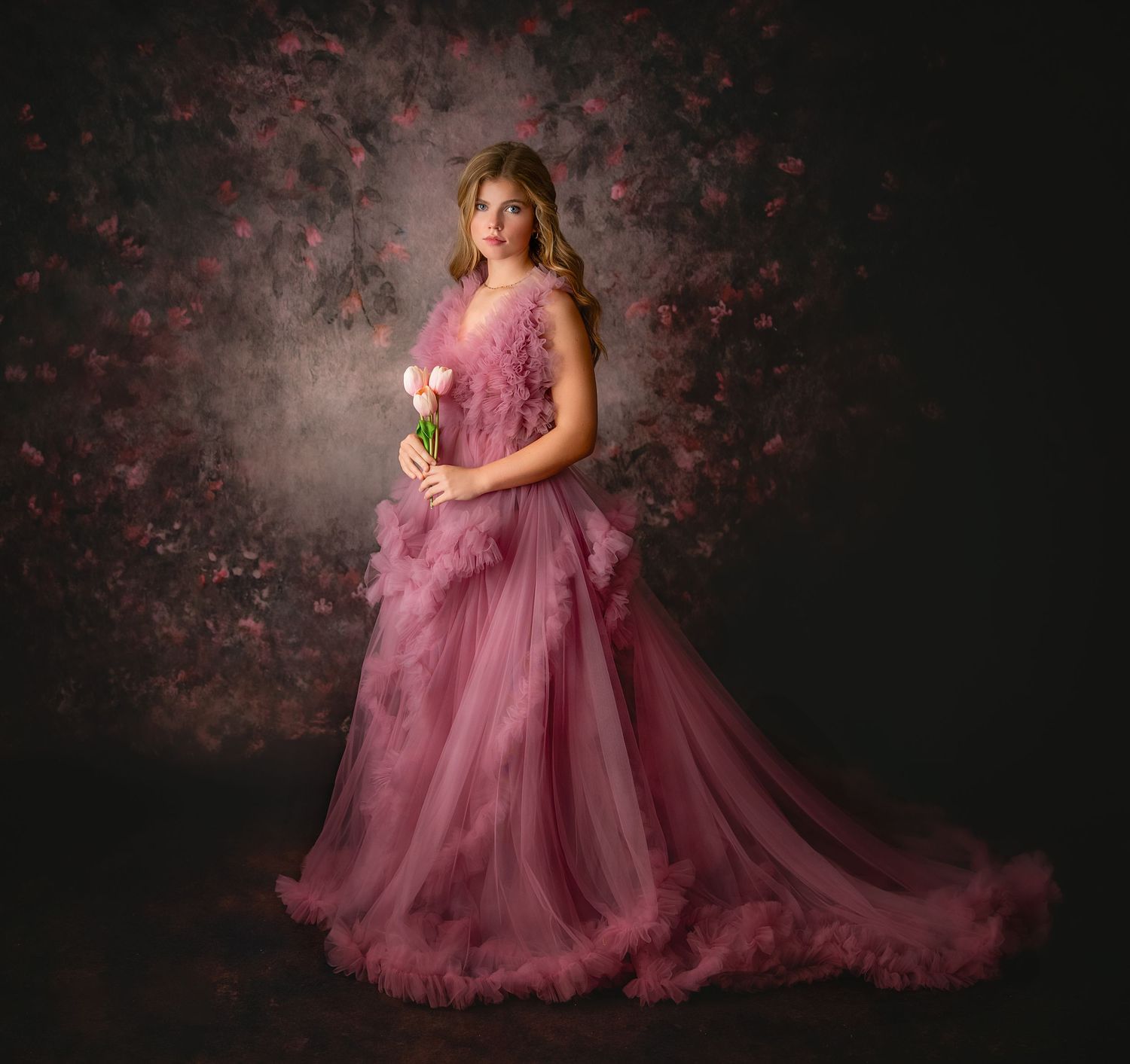 Elegant portrait series featuring a flowing dusty rose tulle gown against a moody dark backdrop.