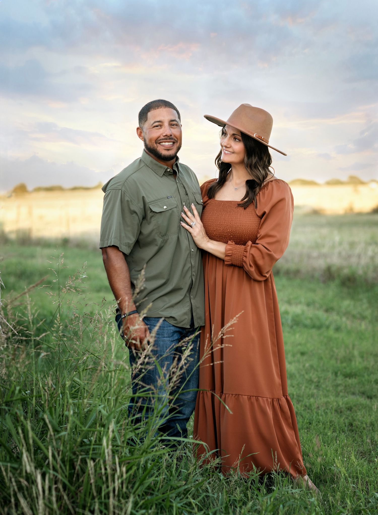Golden hour maternity session in rustic field setting with natural lighting.