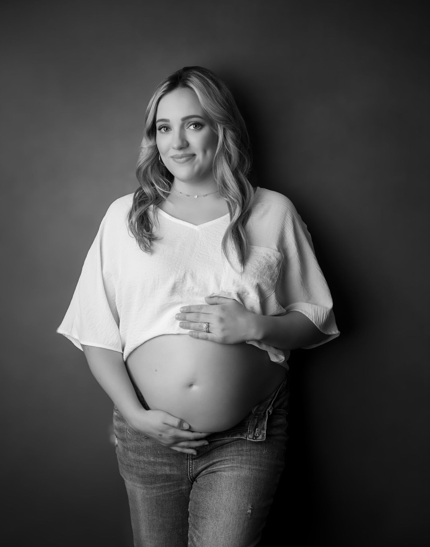 Black and white maternity photographs in casual white t-shirt and jeans.