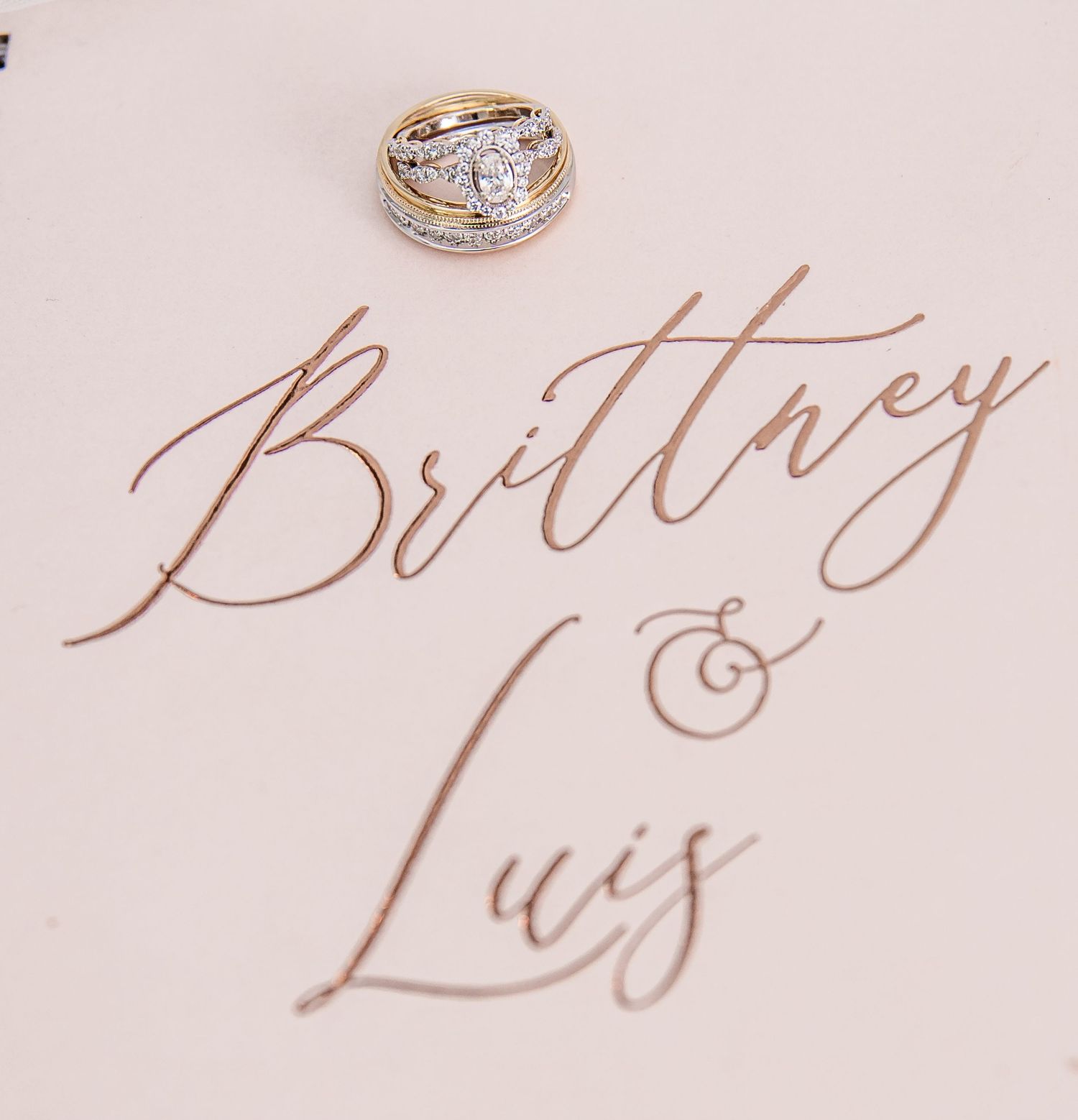 Gold diamond wedding ring photographed with names Brittney and Luis in rose gold calligraphy.