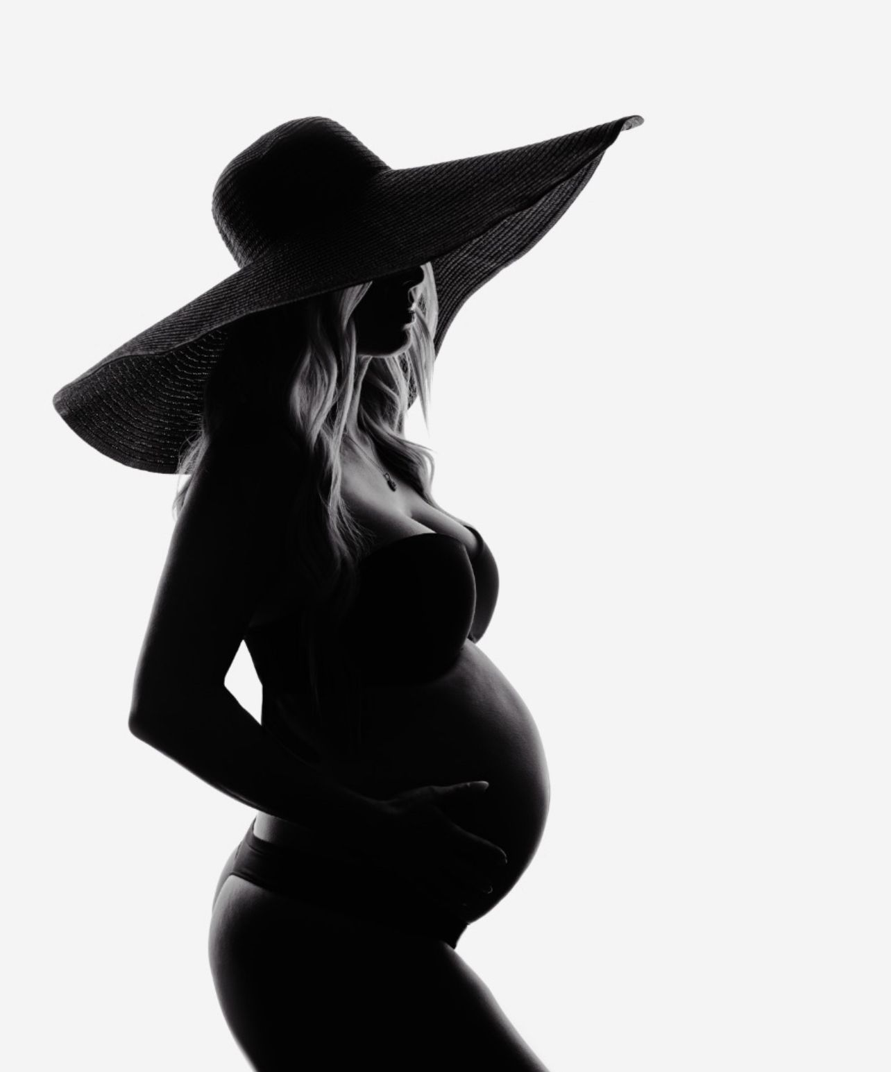 High contrast black and white maternity silhouette series with wide brim hat.