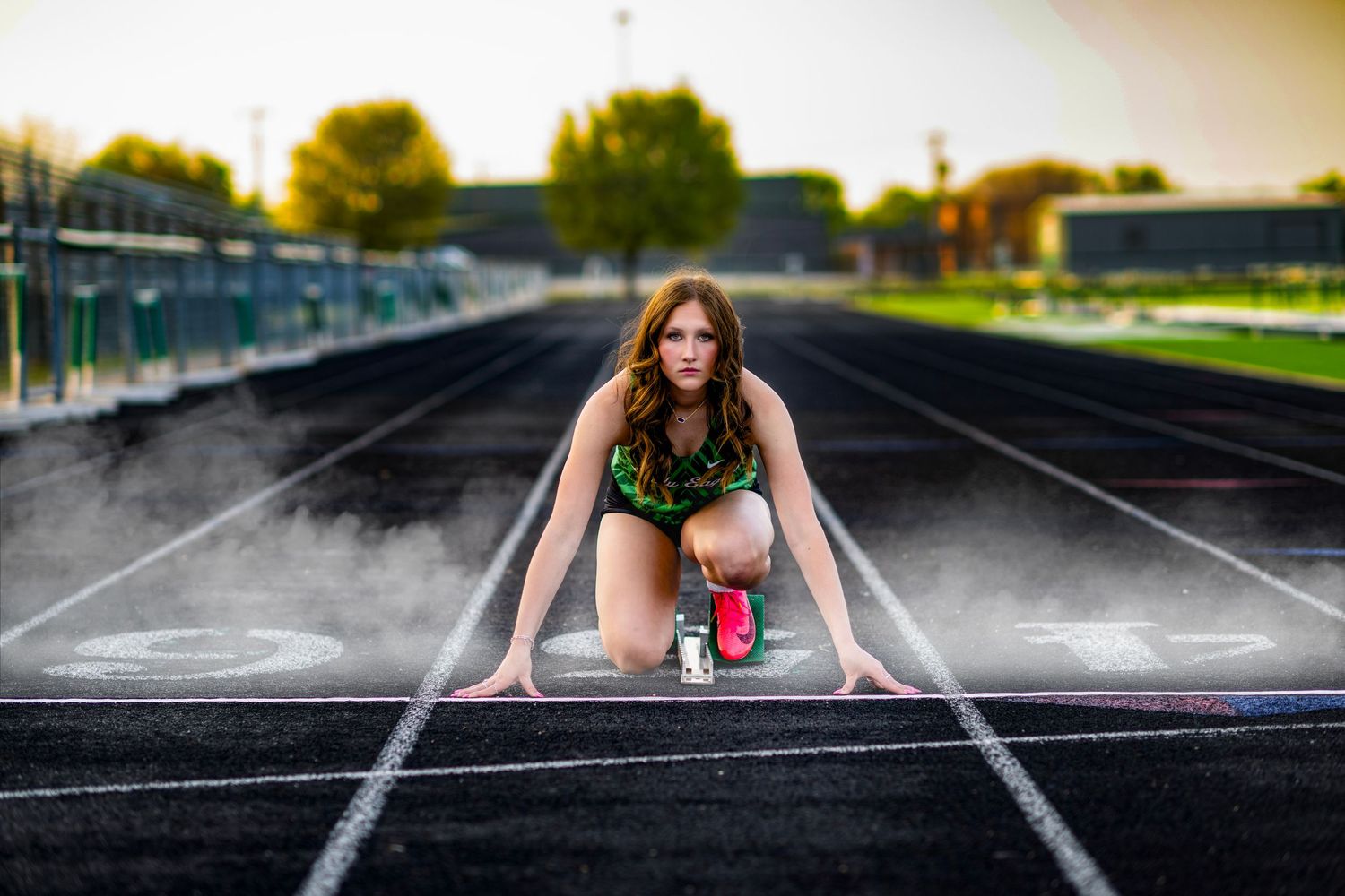 Panoramic sequence showing athlete in green uniform posing on running track.