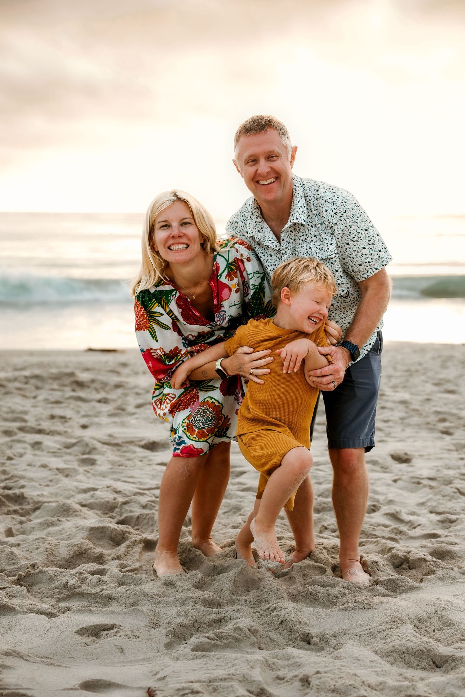 Playful family moment captured on Carmel Beach, California at sunset.