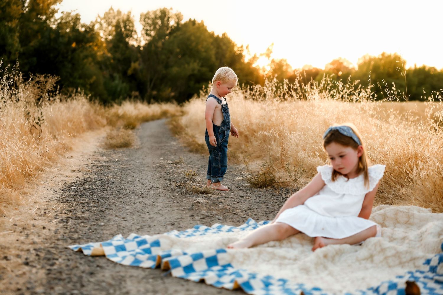 Candid family moments captured during golden hour in a rustic field setting.