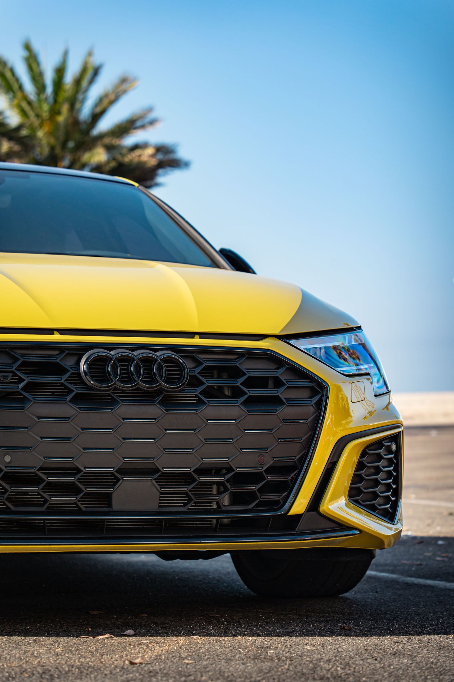 Close-up shots of yellow Audi sports car front grille and bumper details.