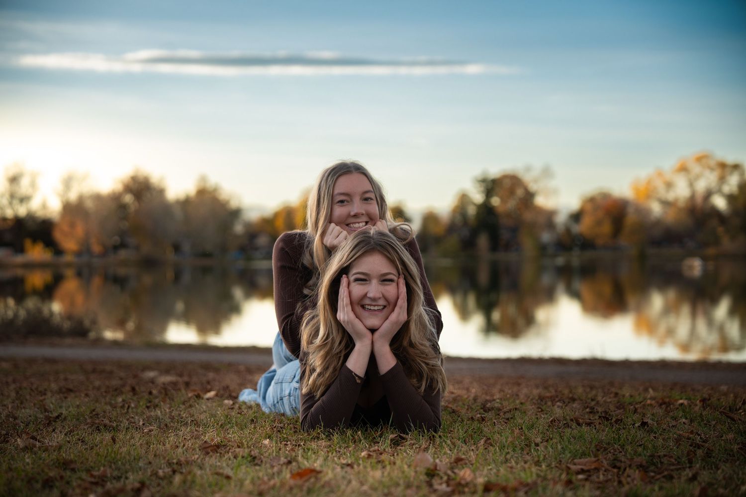 Outdoor portrait series against a scenic lake backdrop during sunset.