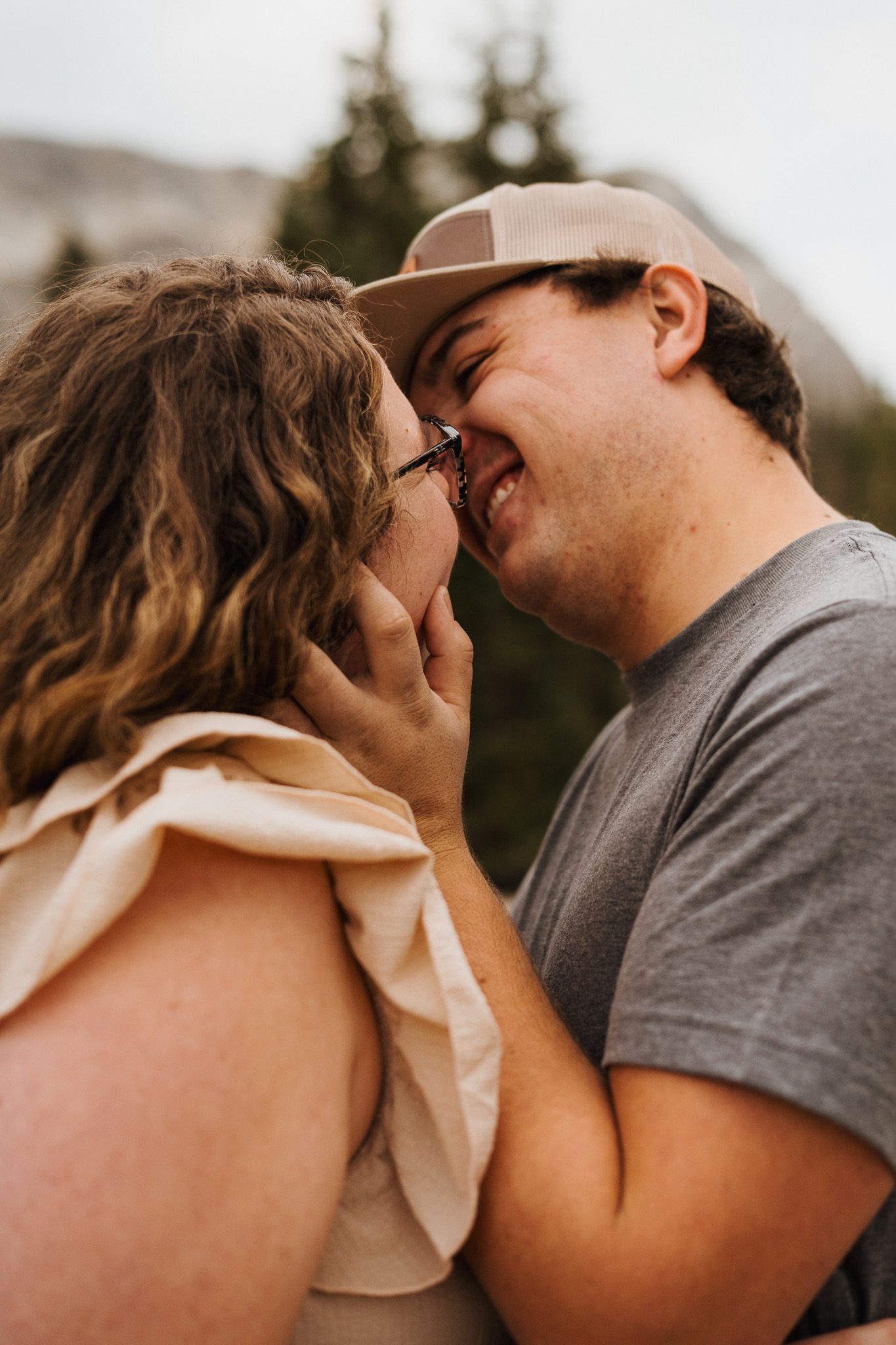 A romantic couple shares an intimate kiss outdoors in a series of candid close-up photos.